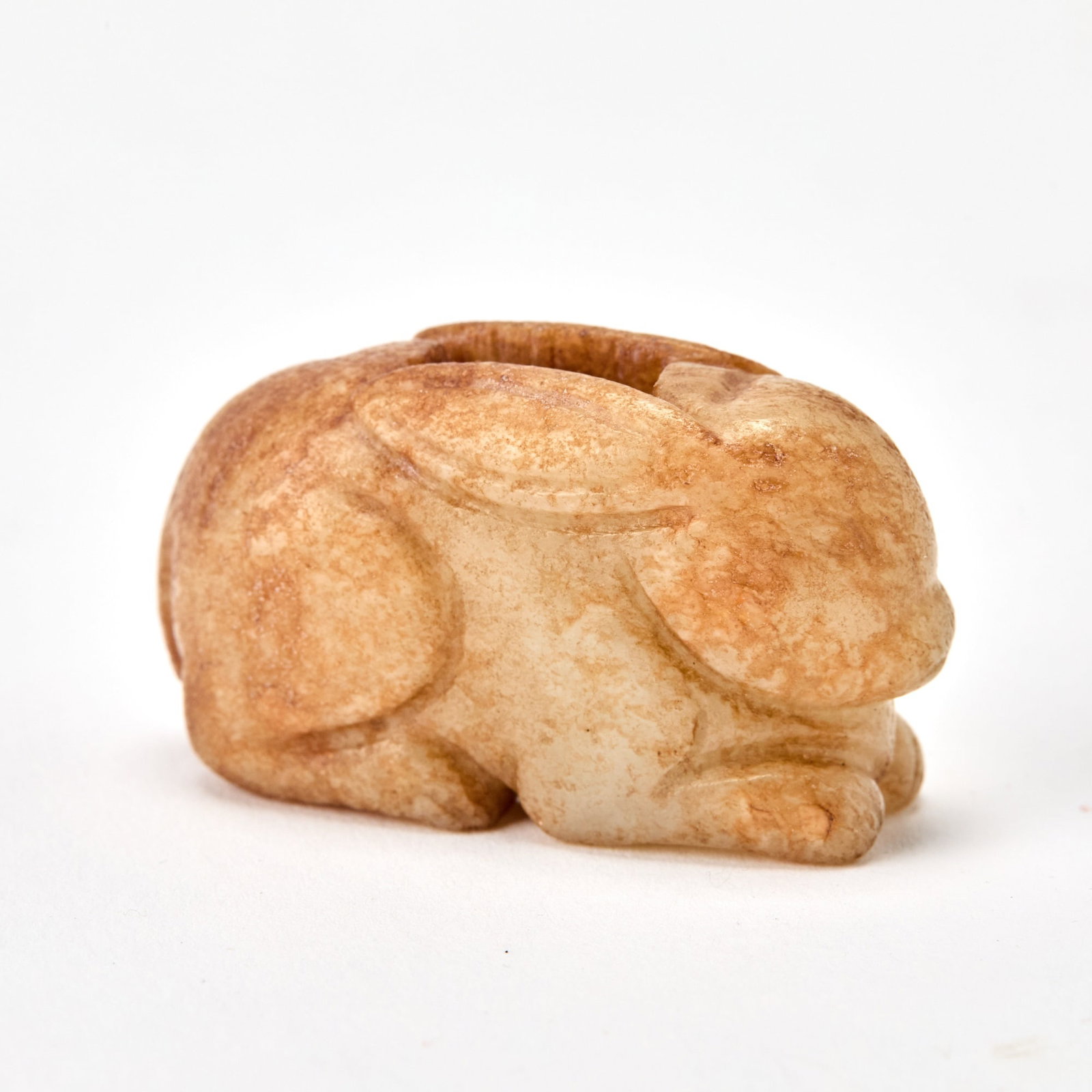 A Chinese Russet and Pale Celadon Jade Toggle Likely Song Dynasty: Carved as a recumbent rabbit. (Length 1 3/4 inches)