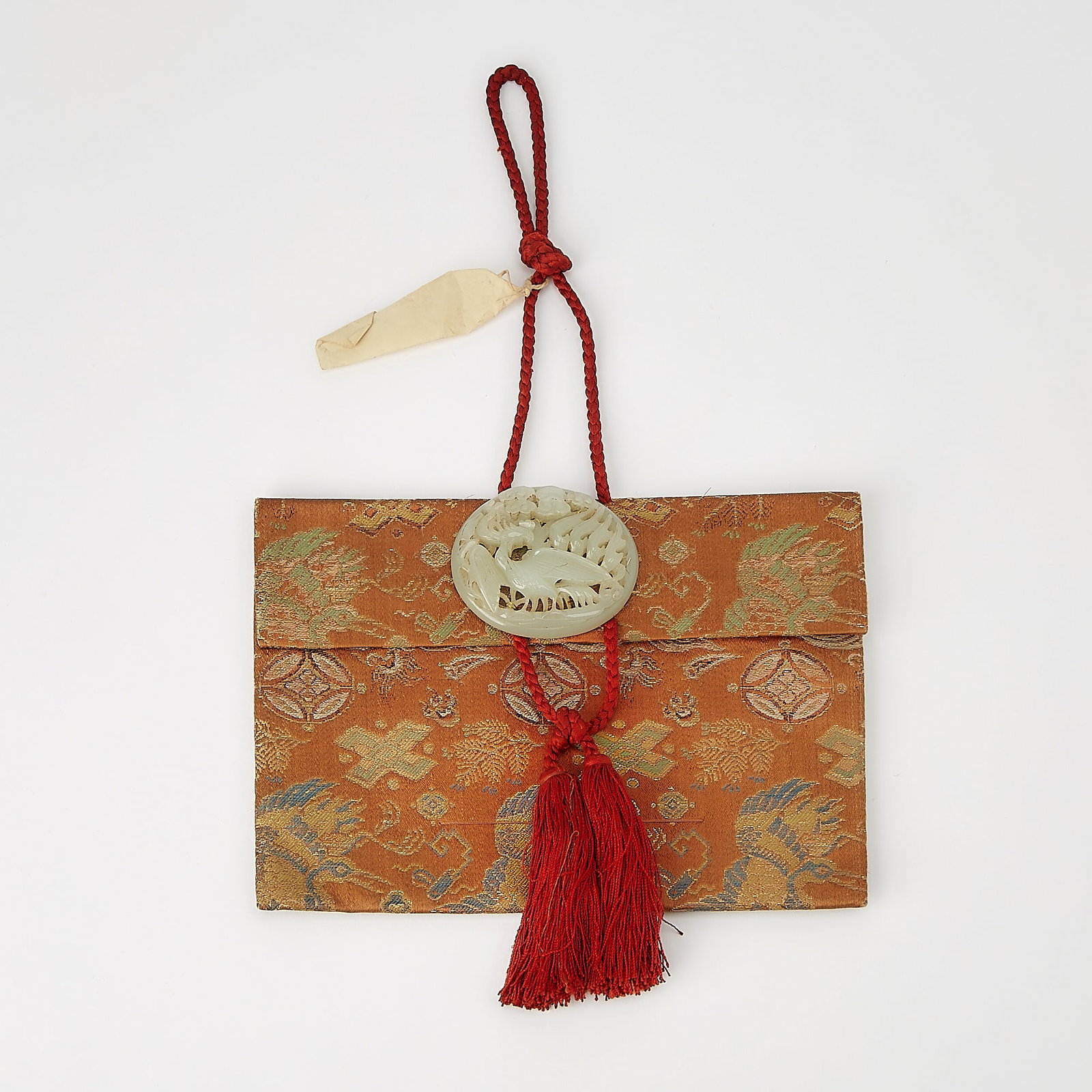 A Chinese Brocade Silk Pouch and a Jade Buckle Qing Dynasty: The pouch decorated with auspicious emblems, and the reticulated jade plaque carved with a phoenix. (Length 8 1/4 inches)
