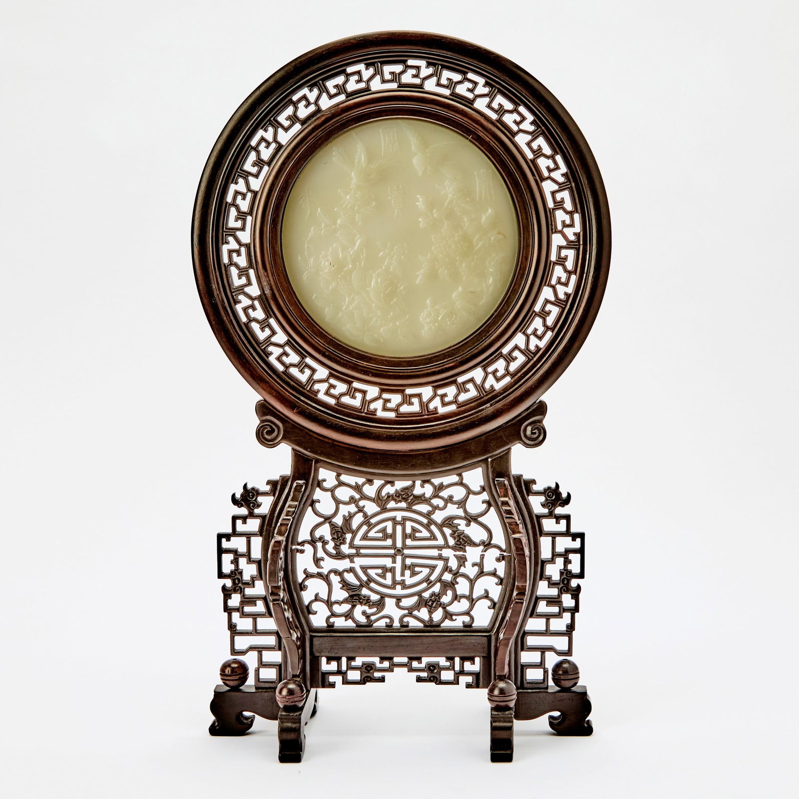 A Chinese Carved White Jade 'Birds and Flowers' Table Screen Qing Dynasty: The panel carved with hua kai fu gui, birds amid blossoming branches, and openwork designs of fu bats and shou emblems. (Overall height 17 inches)