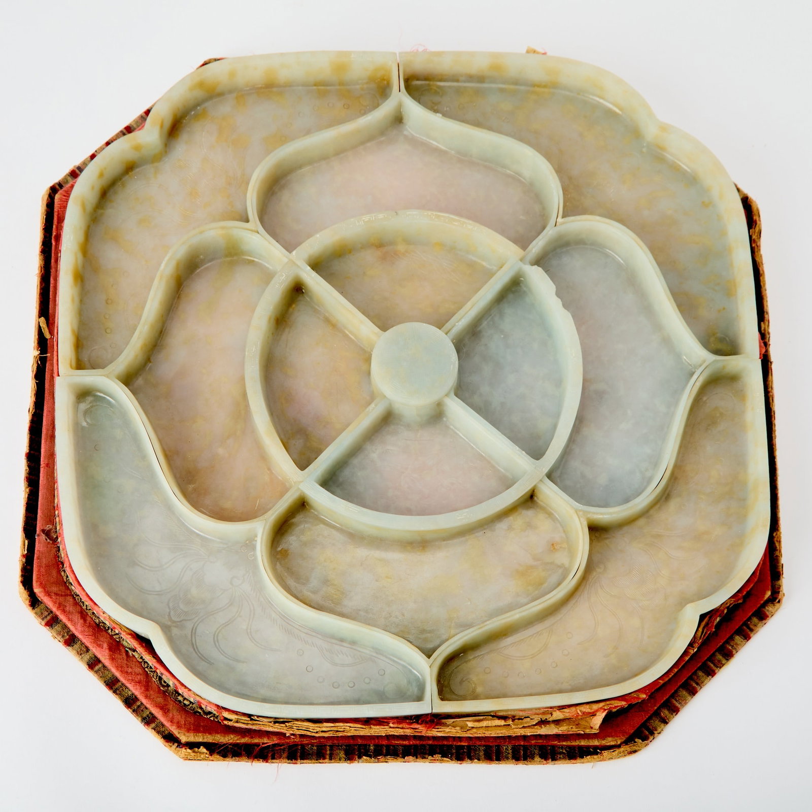 A Rare Chinese Carved Jadeite "Sweetmeat" Set with Silk and Card Stand Qing Dynasty: Formed as a large blossom composed of twelve petal-shaped dishes, carved with cicadas and leafy, blossoming branches. (Diameter 14 1/4 inches)