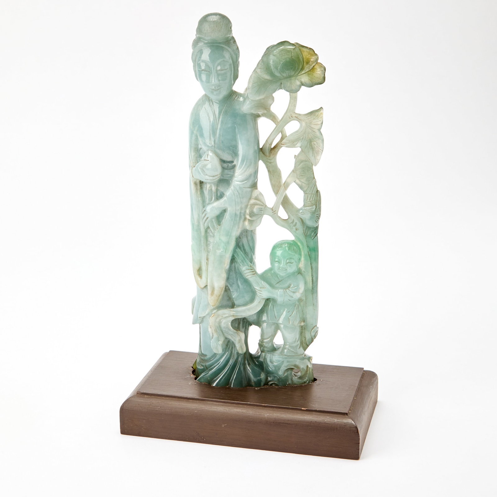 A Chinese Jadeite Figural Group Late Qing Dynasty: Carved as a standing meiren accompanied by a joyful boy and a lotus stem. (Height 10 inches)