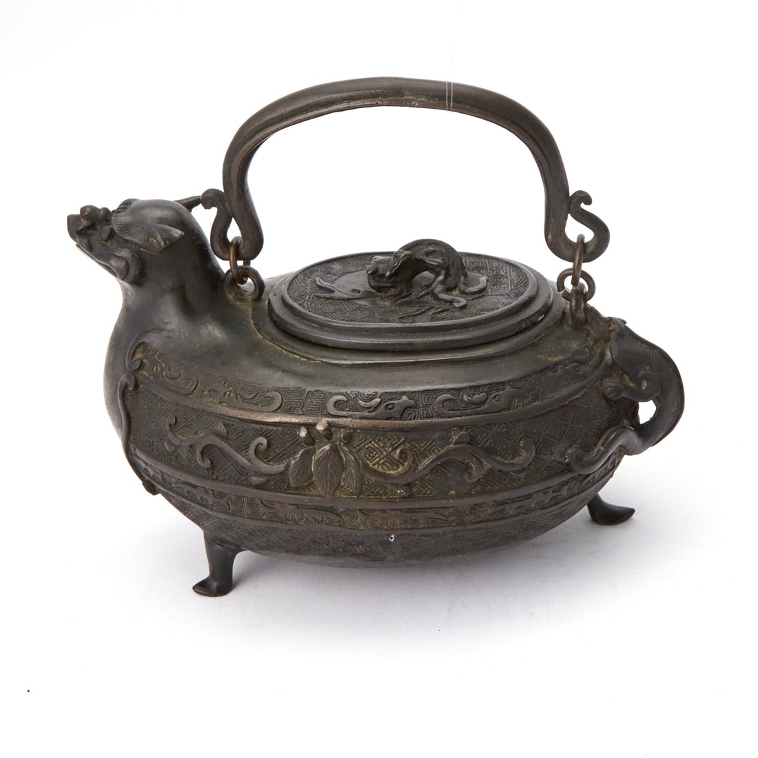 A Chinese Cast Bronze Archaistic Tripod Ewer Qing Dynasty: Cast in the form of a mythical beast, decorated with archaistic bands; with retaining traces of gilding. (Width 9 inches)