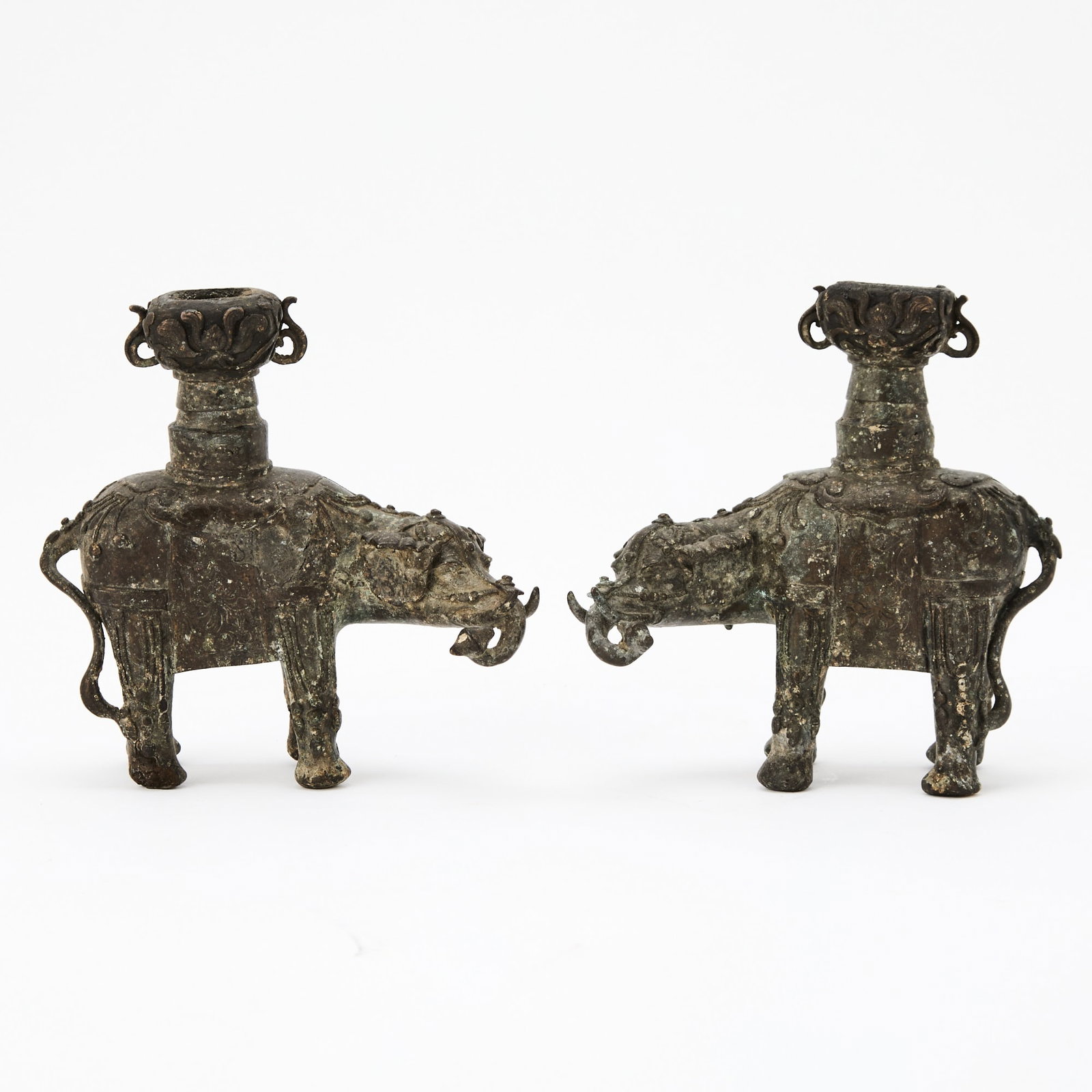 A Pair of Chinese Bronze Elephant Candle Holders Ming Dynasty: Each modeled as an elephant standing foursquare, the trunk curled to one side and supporting a vase on its back. (Length 5 1/2 inches)