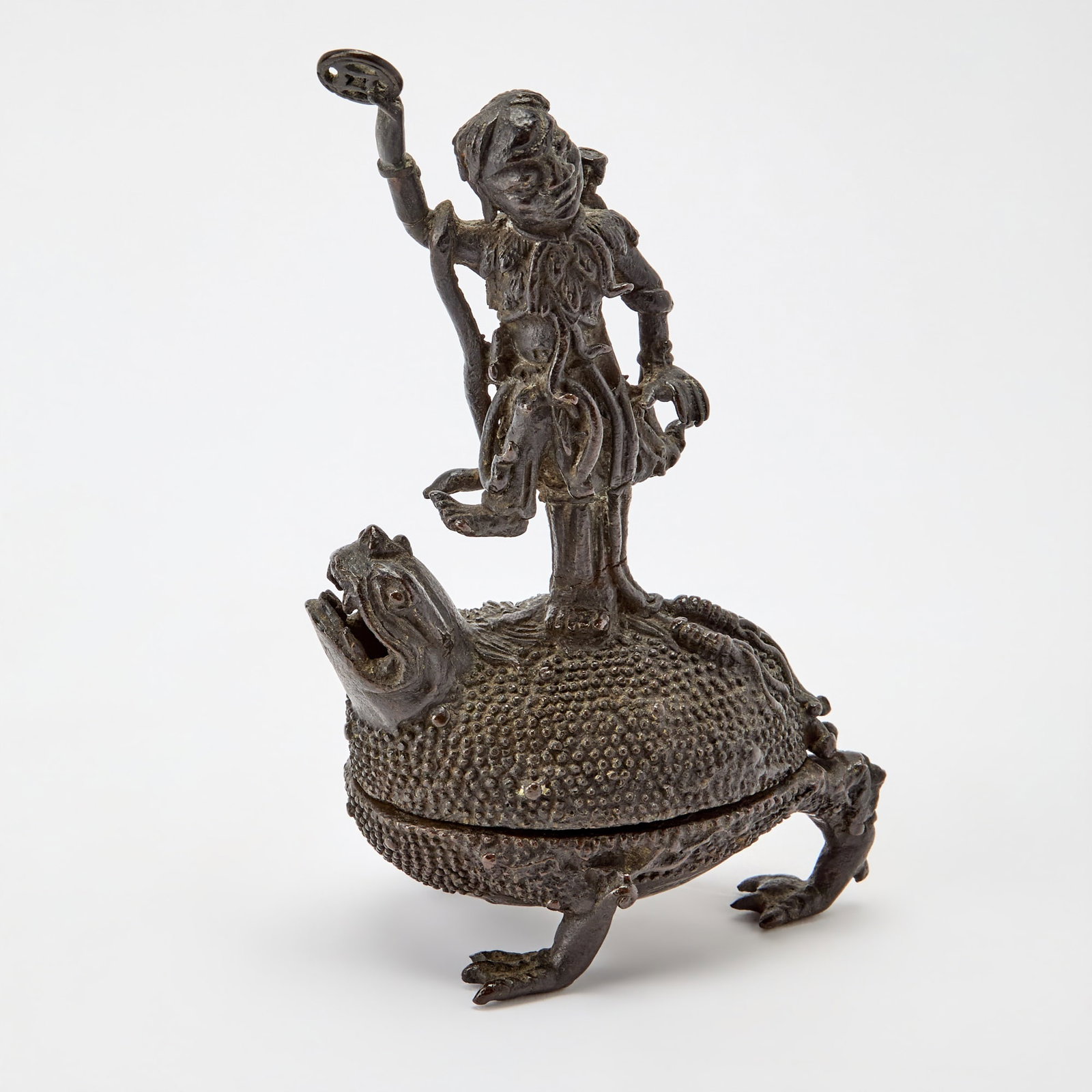 A Chinese Cast Bronze Incense Burner 17th/18th Century: Cast as Liu Hai stnading on a three-legged toad with one foot upraised and a coin in his right hand, a carrying tube and cup clung over his shoulder. (Height 8 1/2 inches)