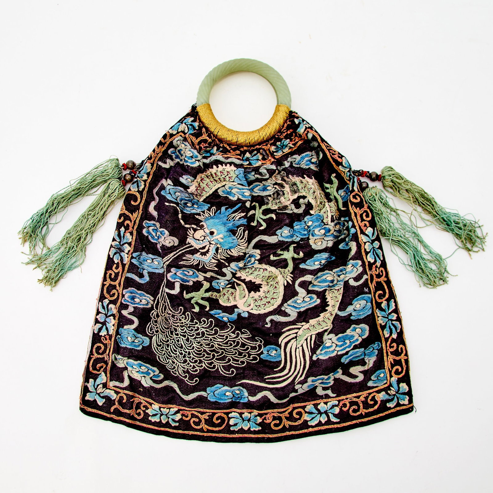 A Chinese Silk Embroidery Pouch with a Pair of Celadon Jade Handles Late Qing Dynasty: The pouch decorated with writhing, scaly dragons amid cloud scrolls, mounted with a pair of twisted-rope-form jade handles. (Length 12 1/4 inches)