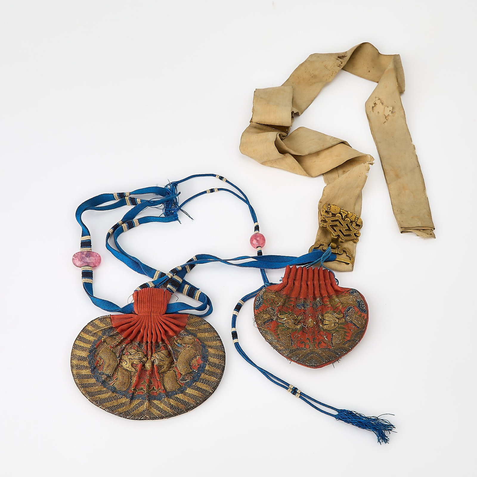 Two Chinese Embroidered Silk Purses, Hebao, with Gilt Bronze Clasp Qianlong-Jiaqing Period: The embroidered purses with metallic thread decoration and blue ribbons with glass bead toggles joined to gilt bronze clasp in the form of a fu bat and Buddhist emblem; with white silk belt. (Width of