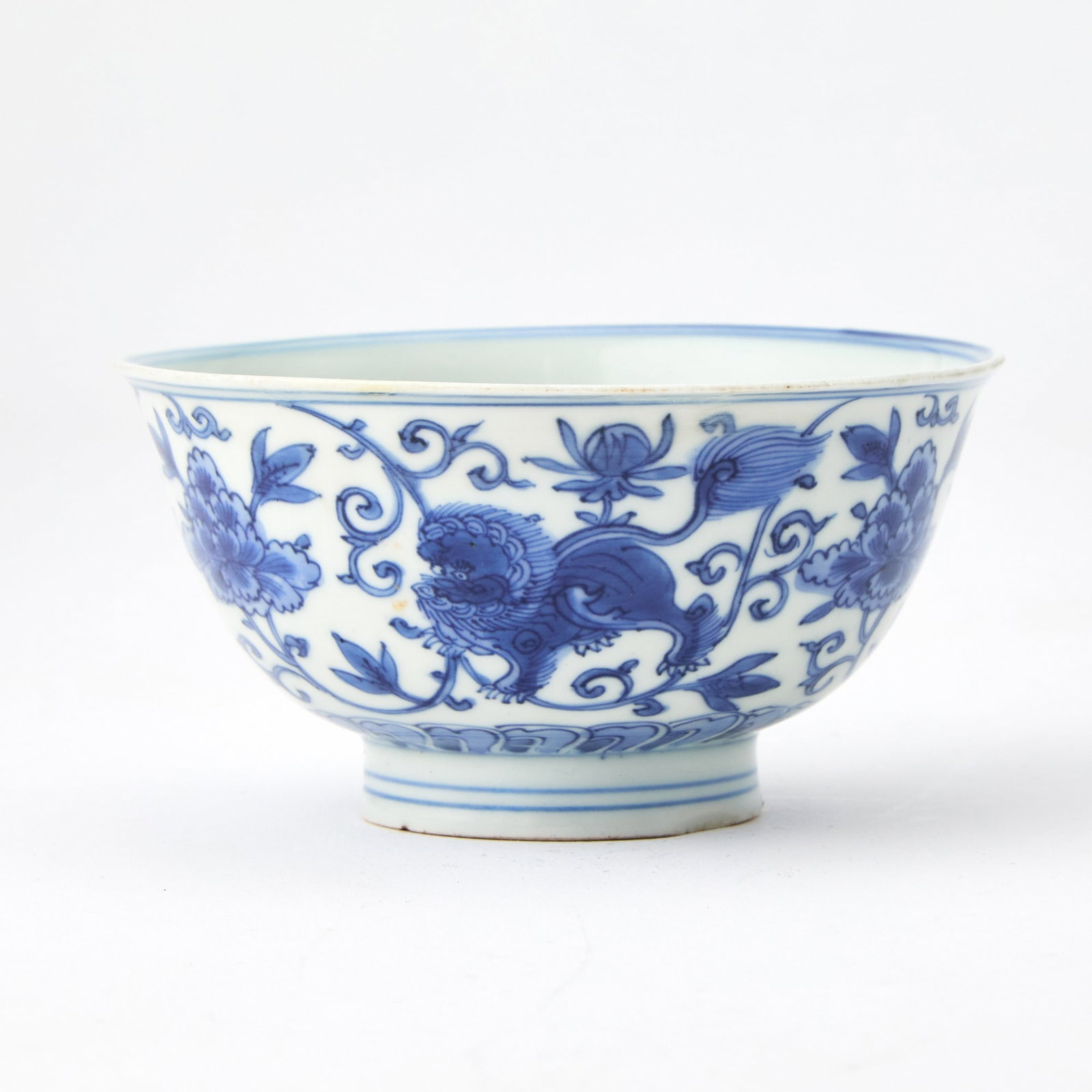 A Chinese Blue and White Porcelain Bowl Wanli Mark, Kangxi Period: Decorated with four qilin amongst leafy vines bearing lotus blossoms. (Diameter 4 1/2 inches) There is a small area of restoration to the rim, visible under UV light (see photos).