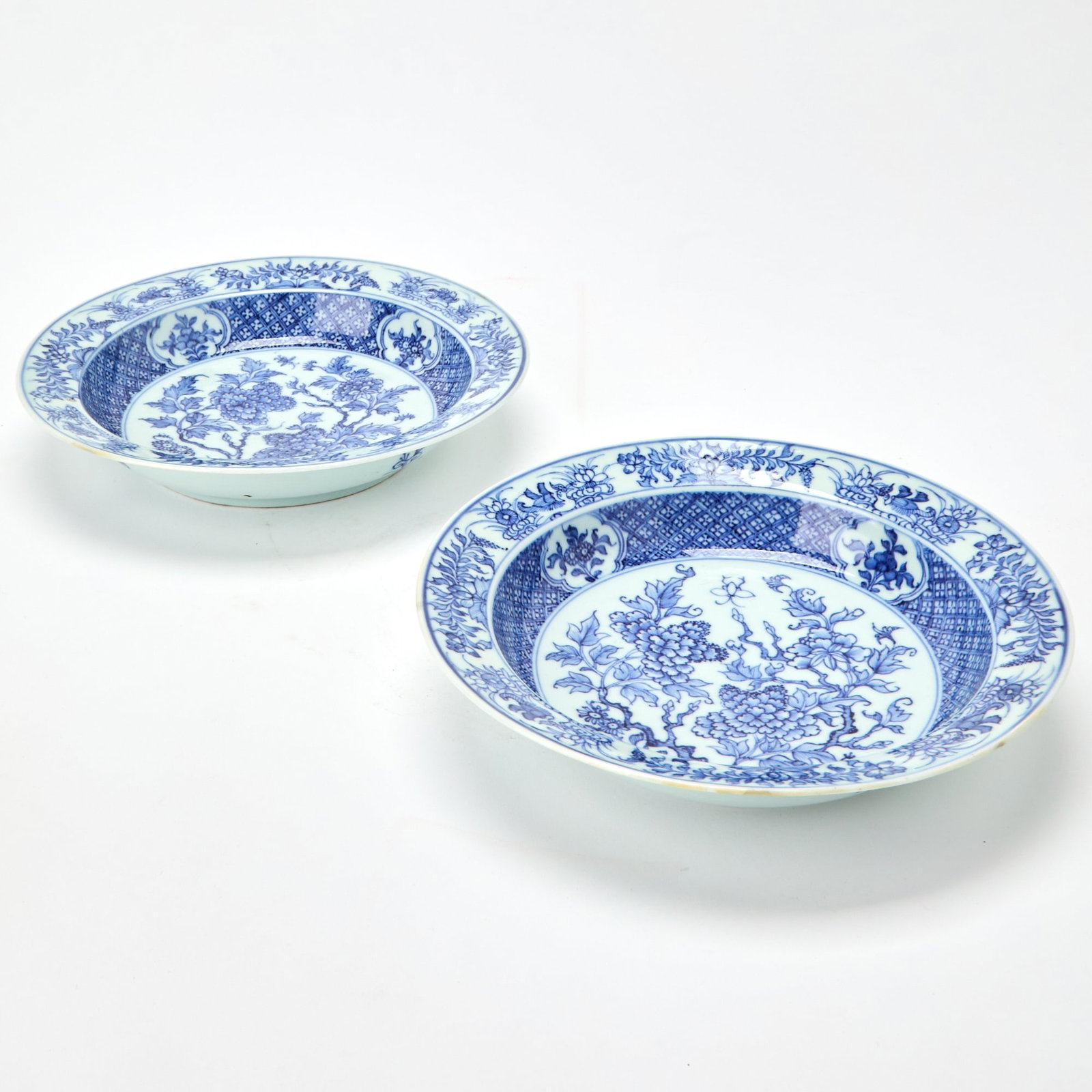 A Pair of Chinese Blue and White Porcelain Dishes Qianlong Period: Each with rounded sides rising to an everted rim, the interior decorated with blossoming branches and butterflies, enclosed by two decorative borders. (Diameter 8 1/2 inches) Under UV light inspection