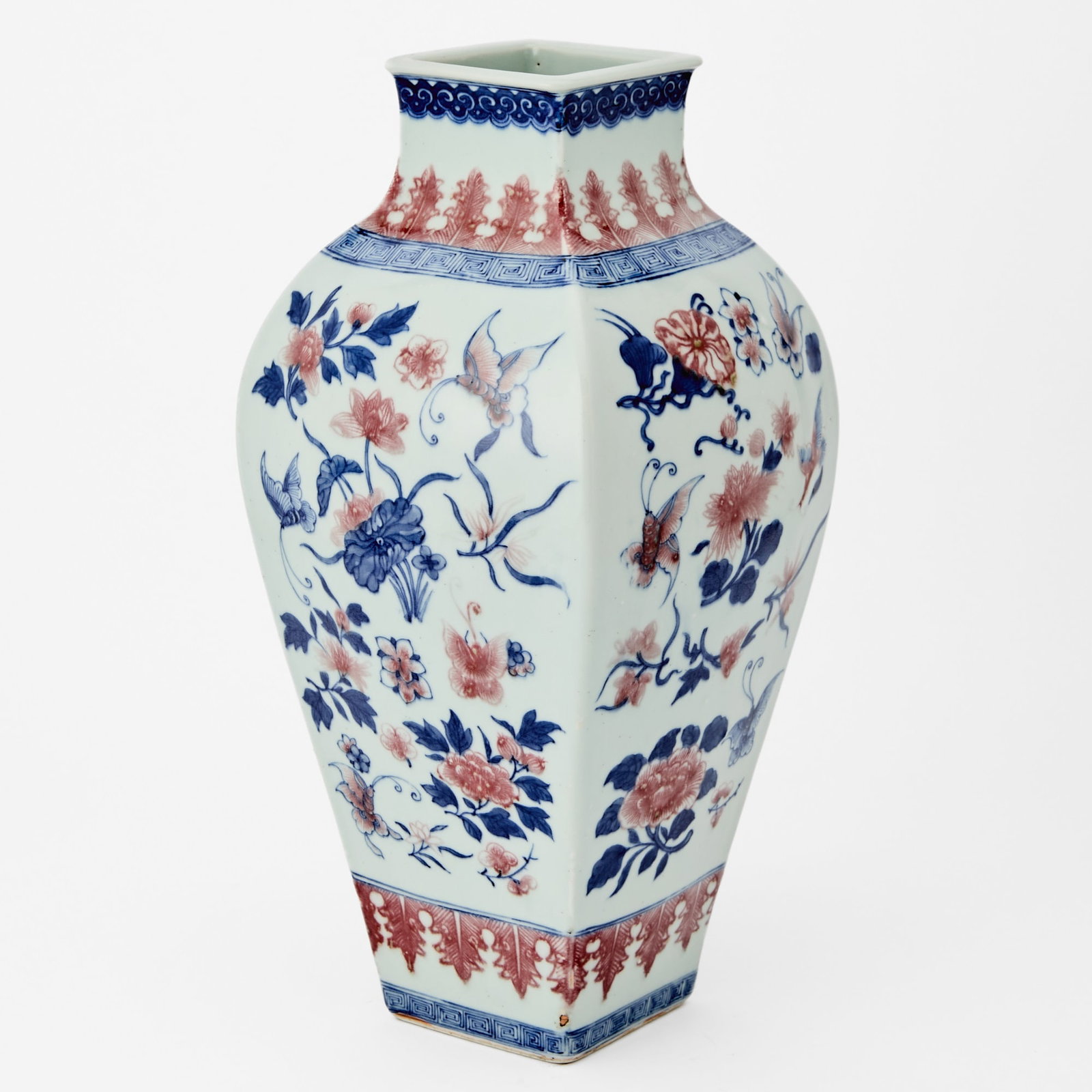 A Chinese Blue and Copper Red Porcelain Vase Daoguang Period: Of square hu form, decorated with a variety of blossoms borne on leafy stems, and butterflies. (Height 14 inches)