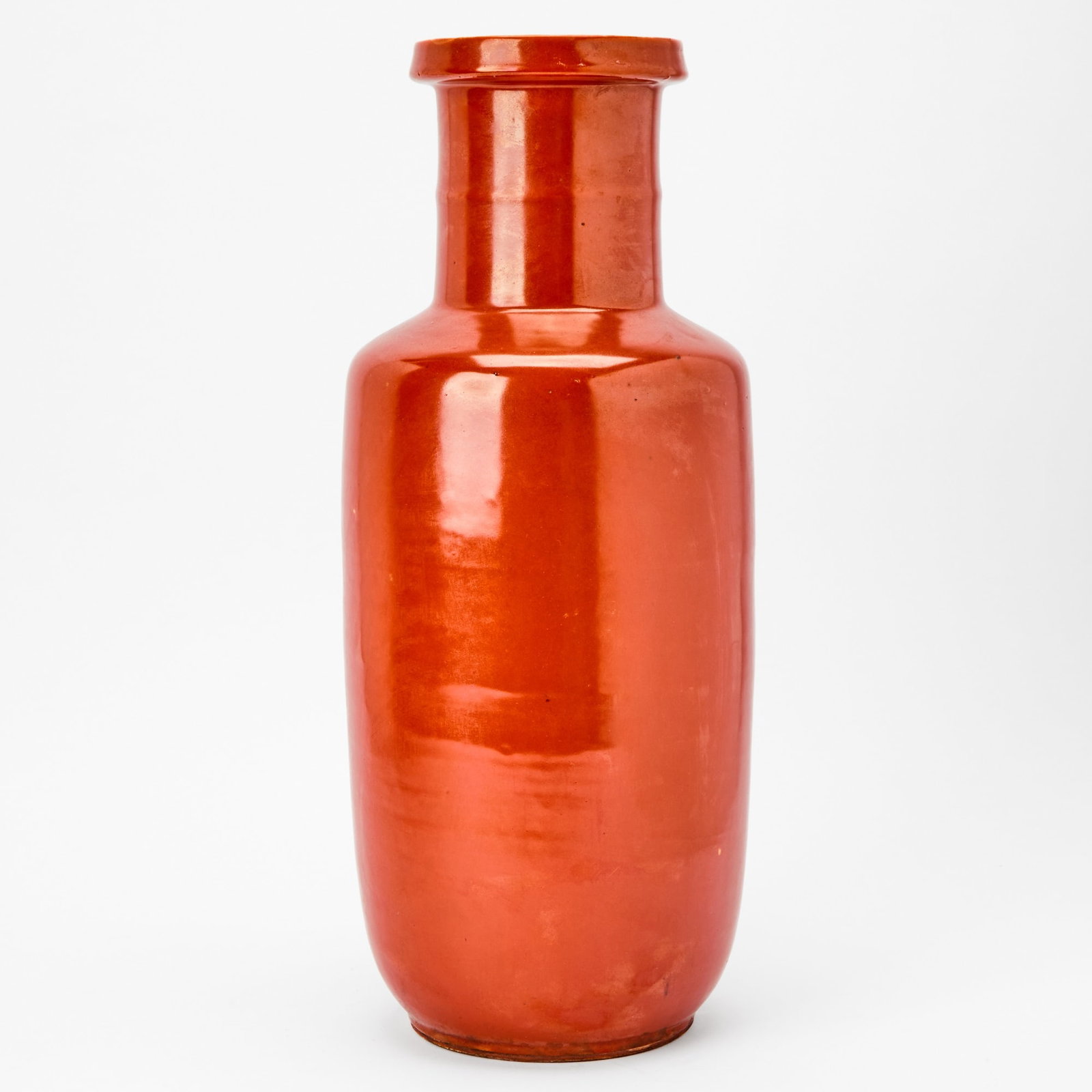 A Chinese Coral Glazed Porcelain Rouleau Vase Qing Dynasty: The exterior covered overall in a rich coral red glaze. (Height 17 1/2 inches)
