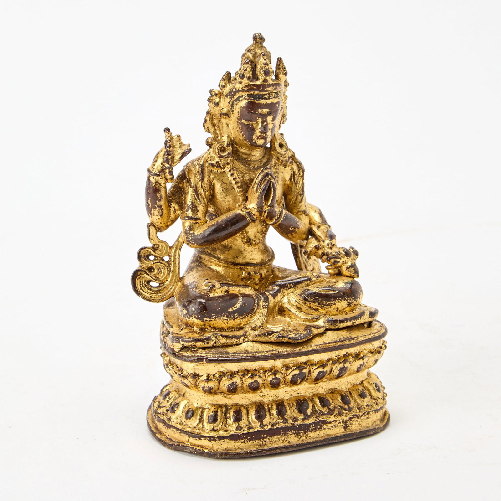 A Nepalese Gilt Lacquer Figure of Shadkakshari Lokeshavara 16th-17th Century: Seated upon a double-lotus base, the figure depicted in dhyanasana . (Height 5 inches)