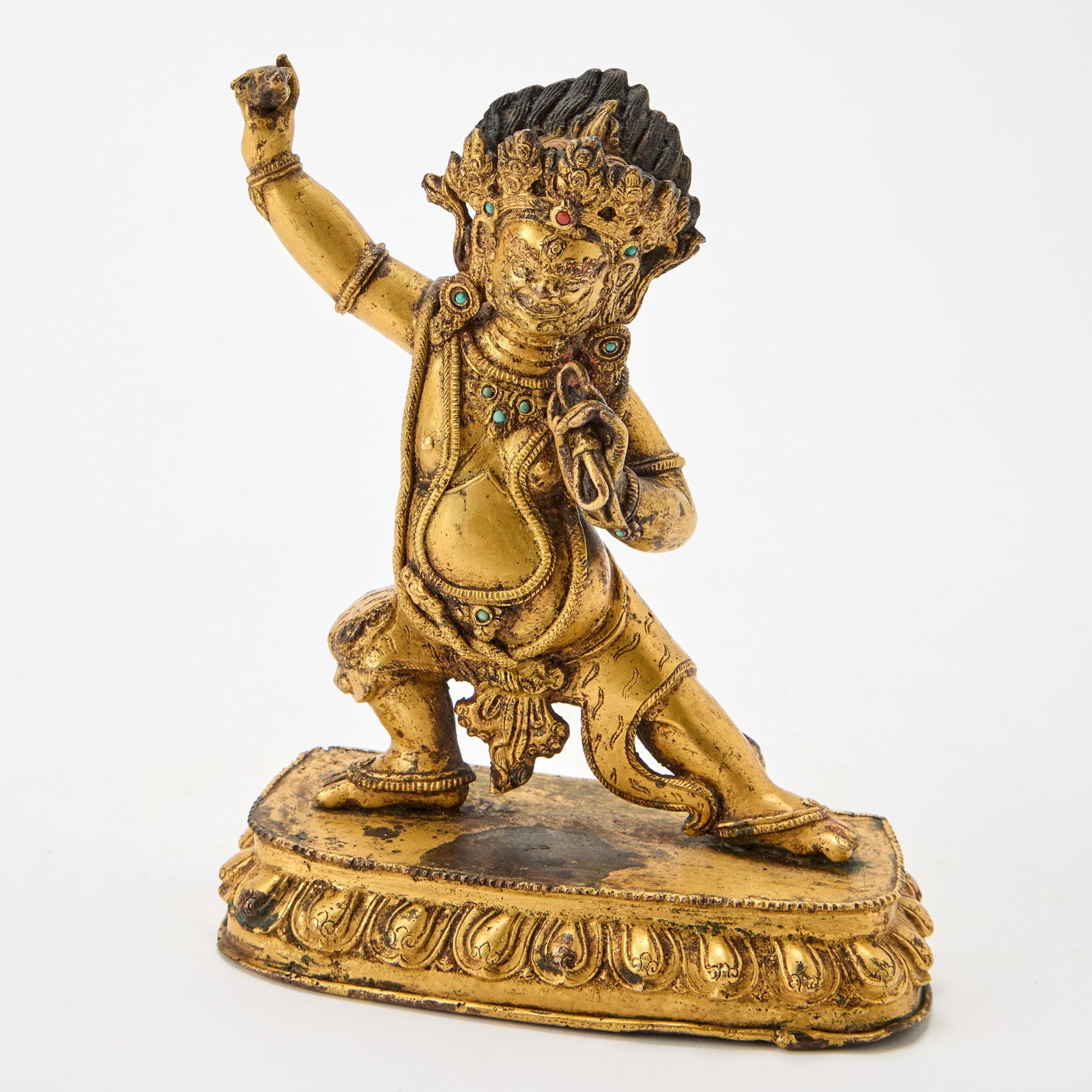 A Tibetan Gilt Bronze Figure of Vajrapani 17th Century: The wrathful guardian standing in a trampling position on a lotus stand, his left hand holding the vajra, and his right hand with a noose. (Height 7 3/4 inches)