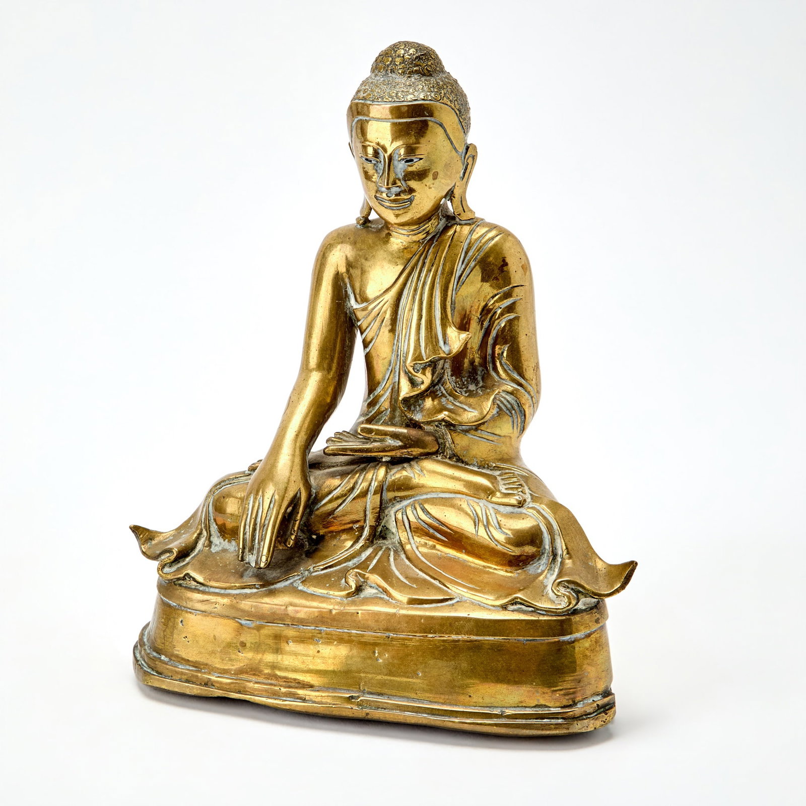 A Burmese Bronze Figure of Buddha 19th Century: The seated Buddha depicted atop a waisted pedestal. (Height 10 inches)