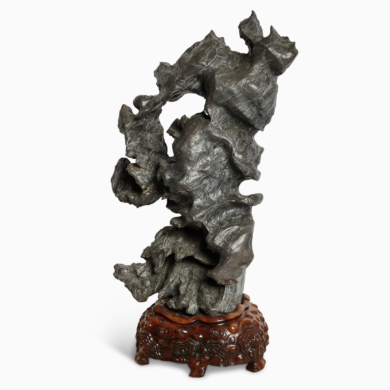 An Exceptionally Large Chinese Scholar's Rock, Lingbi: Of tall naturalistic form, the dark gray stone with twisting overhangs and deep crevices; custom hardwood base. (Height 49 inches)