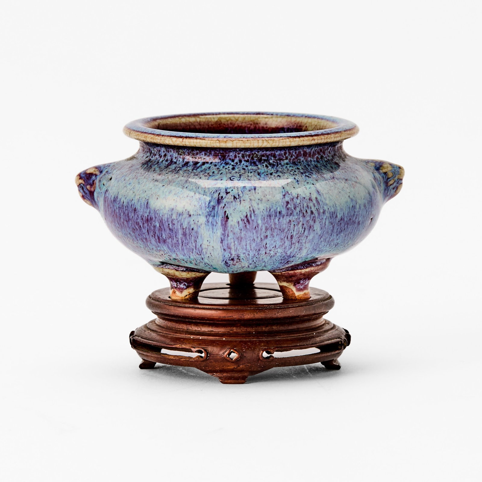 A Chinese Flambe-Glazed Tripod Censer Qing Dynasty: Of compressed form with three short, splayed feet, the body molded with a pair of mythical beast handles, and covered in rich purple glaze with pale blue splashes. (Diameter 4 1/2 inches)