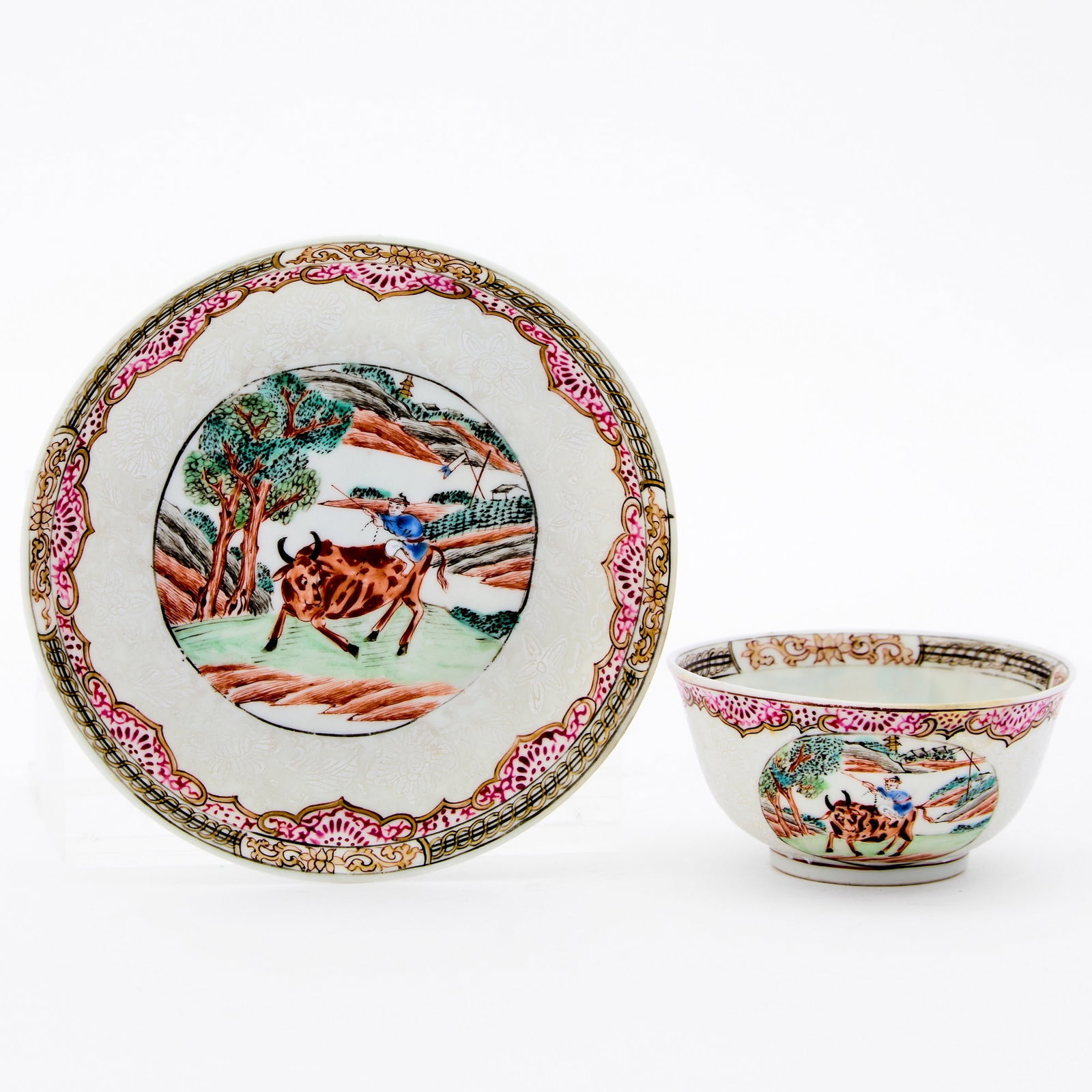 A Chinese Slip-Decorated Famille Rose Porcelain Saucer and Cup 18th Century: Decorated to show panels enclosing scenes of 'boy and buffalo' in landscape, all surrounded by floral scrolls and decorative bands. (Diameter of saucer 4 1/2 inches)
