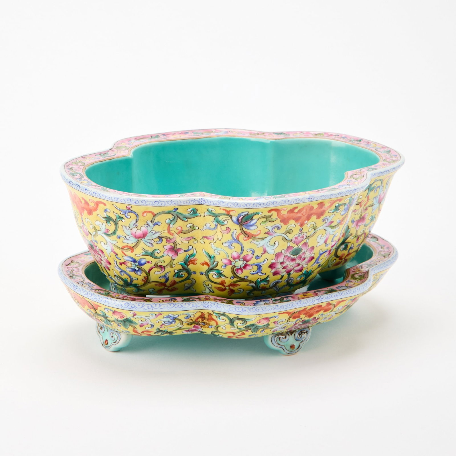 A Chinese Famille Rose Porcelain Jardinière and Stand Republic Period: Of lobed quatrefoil form, the exterior decorated with continuous lotus scrolls reserved against a yellow ground. (Length 7 3/4 inches)