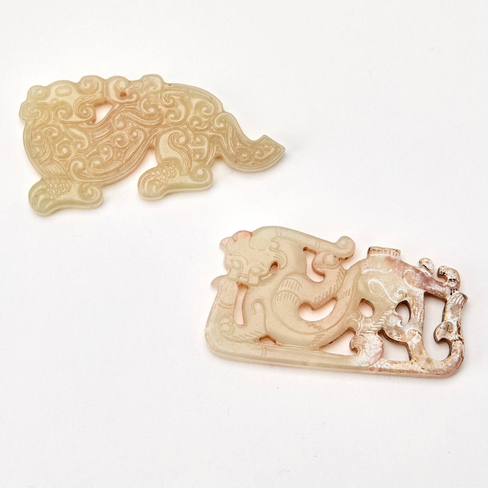 Two Chinese Archaistic Jade Carvings: Each of flattened form; comprising a dragon and a mythical beast. (Length of largest 1 3/4 inches)
