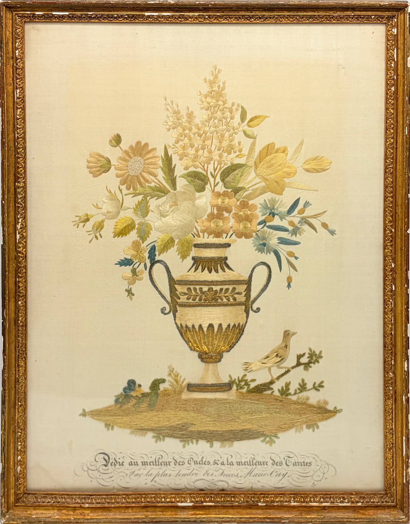 Neoclassical French Needlework Picture with Urn of Flowers: Early 19th century Worked in silk and metallic threads, the urn with a bird perched below, all above an ink inscription surrounded by flourishes. Sight 17 1/4 x 13 inches Frame: 14 1/2 x 18 3/4 inches