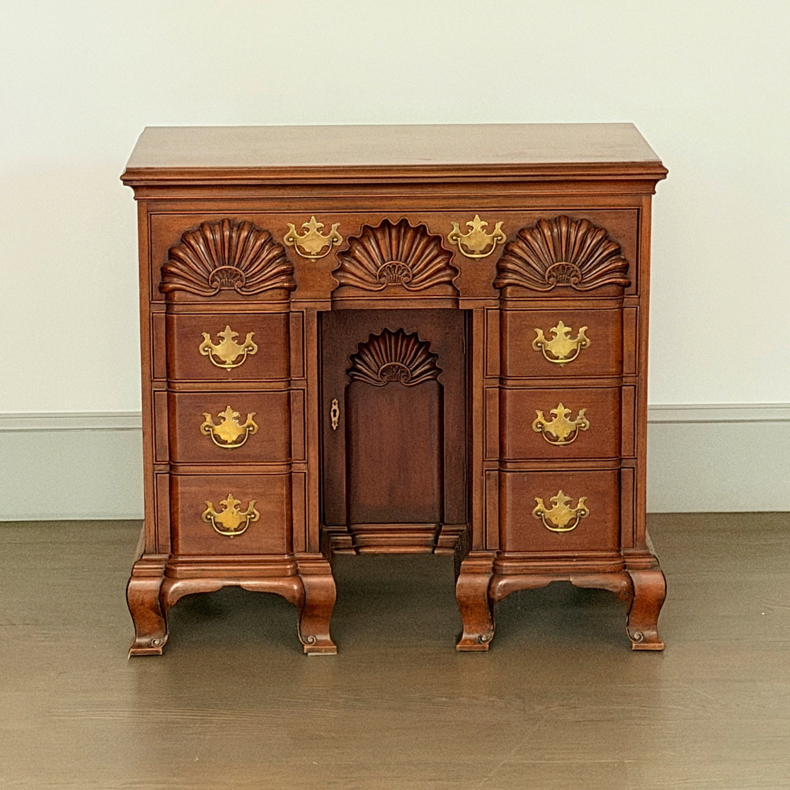 Chippendale Mahogany Four Shell Kneehole Dressing Table: 20th Century The molded top above cockbeaded drawers and an ogee bracket base. Height 34 inches, width 36 1/2 inches, depth 20 inches. slight sunfading