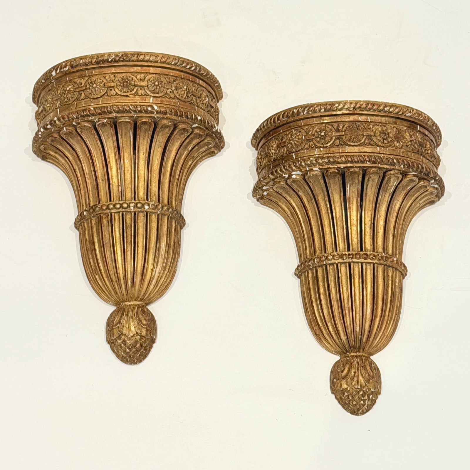 Pair of Empire Style Wall Brackets: Late 19th/early 20th century Each with floral frieze above gathered tapering ribs. Height 15 inches.