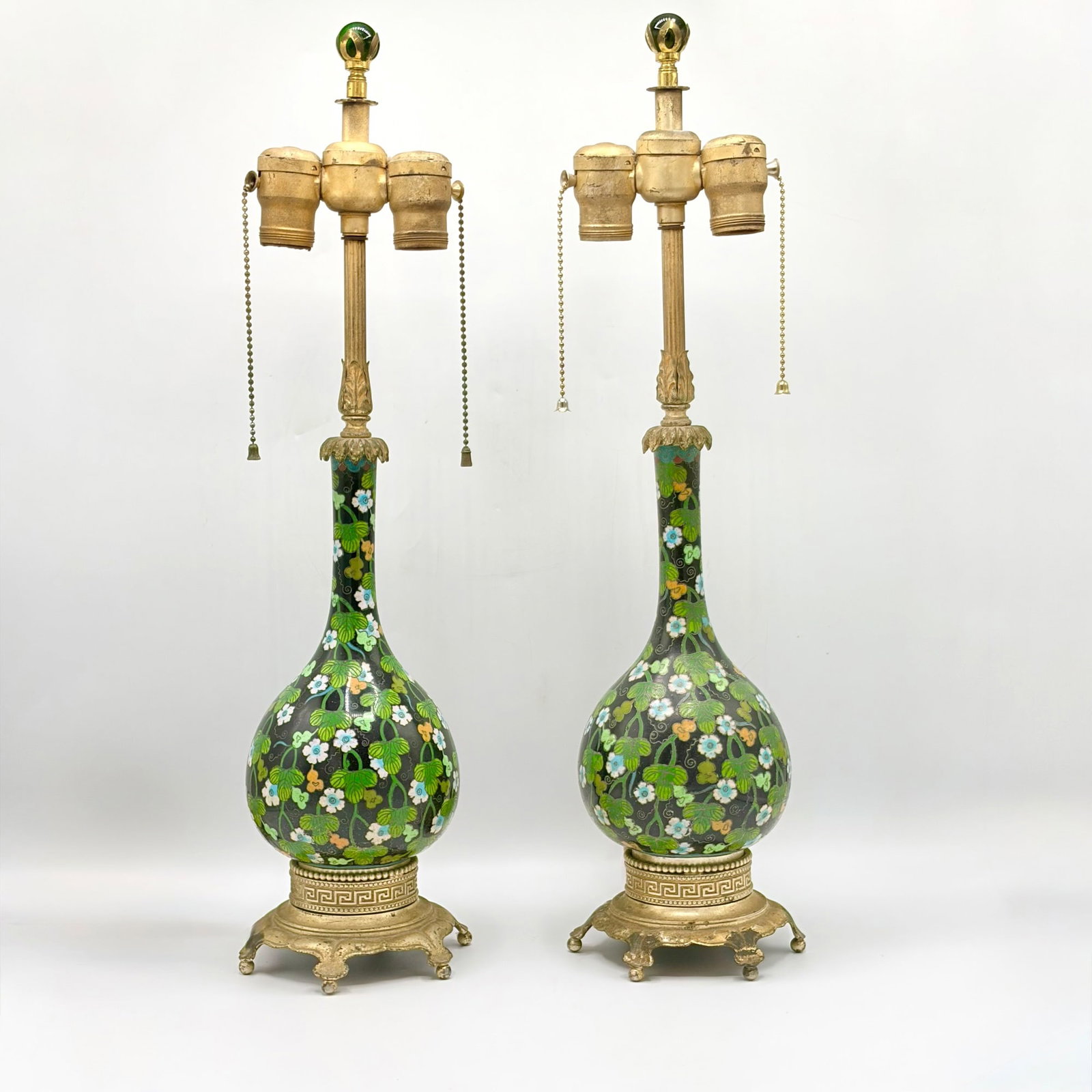 Pair of Cloisonne Enamel Bottle Vase Lamps: Late 19th century With vining floral design on a black ground, with gilt metal mounts. Height overall 22 1/4 inches
