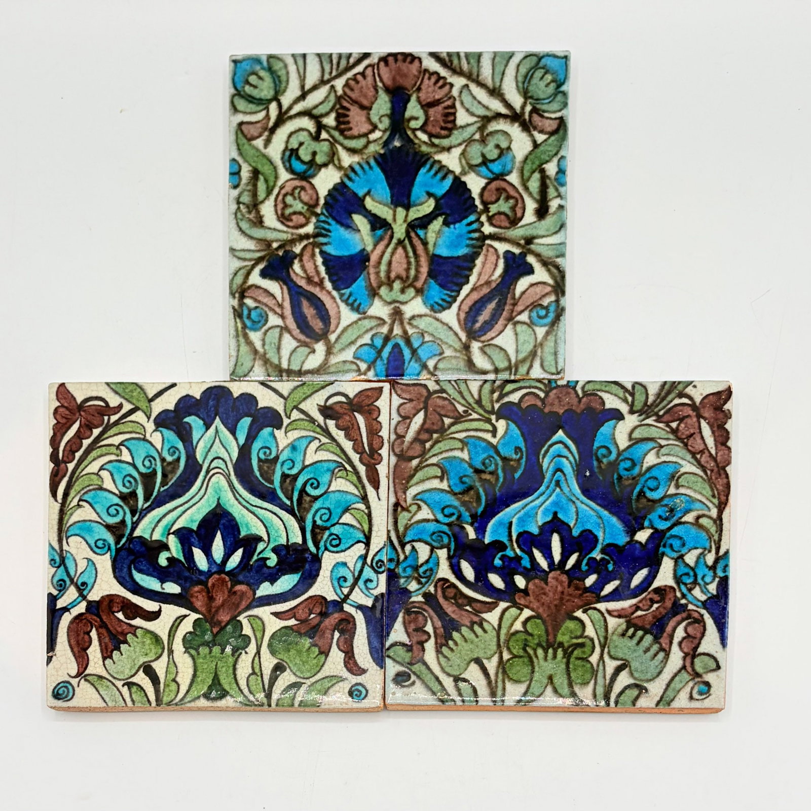 Three William de Morgan Glazed Earthenware Islamic Design Tiles: England, circa 1882-1898 Two examples with impressed De Morgan Merton Abbey mark to reverse, one example with impressed DM 98 mark to reverse Each 6 x 6 inches. 9.1, 9.2 mark h, 9.3 mark n, ill.