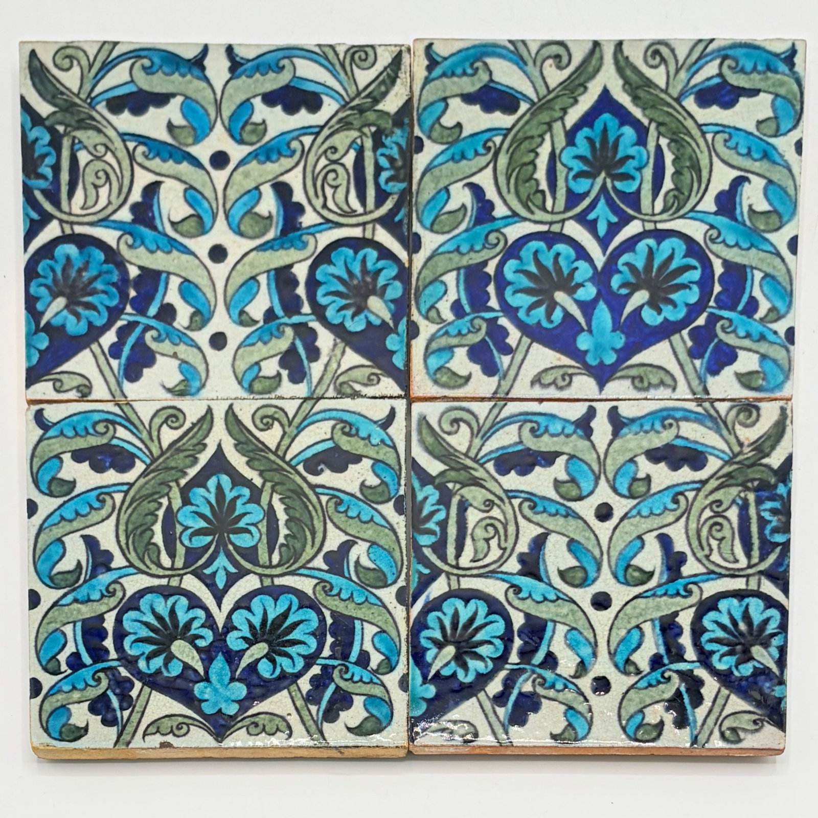 Four Glazed Earthenware William De Morgan Islamic Design Tiles: Fulham, England, circa 1888-1898 Each with impressed Sand's End Pottery mark to the reverse. Each 6 x 6 inches. Provenance: The Jon Catleugh Collection