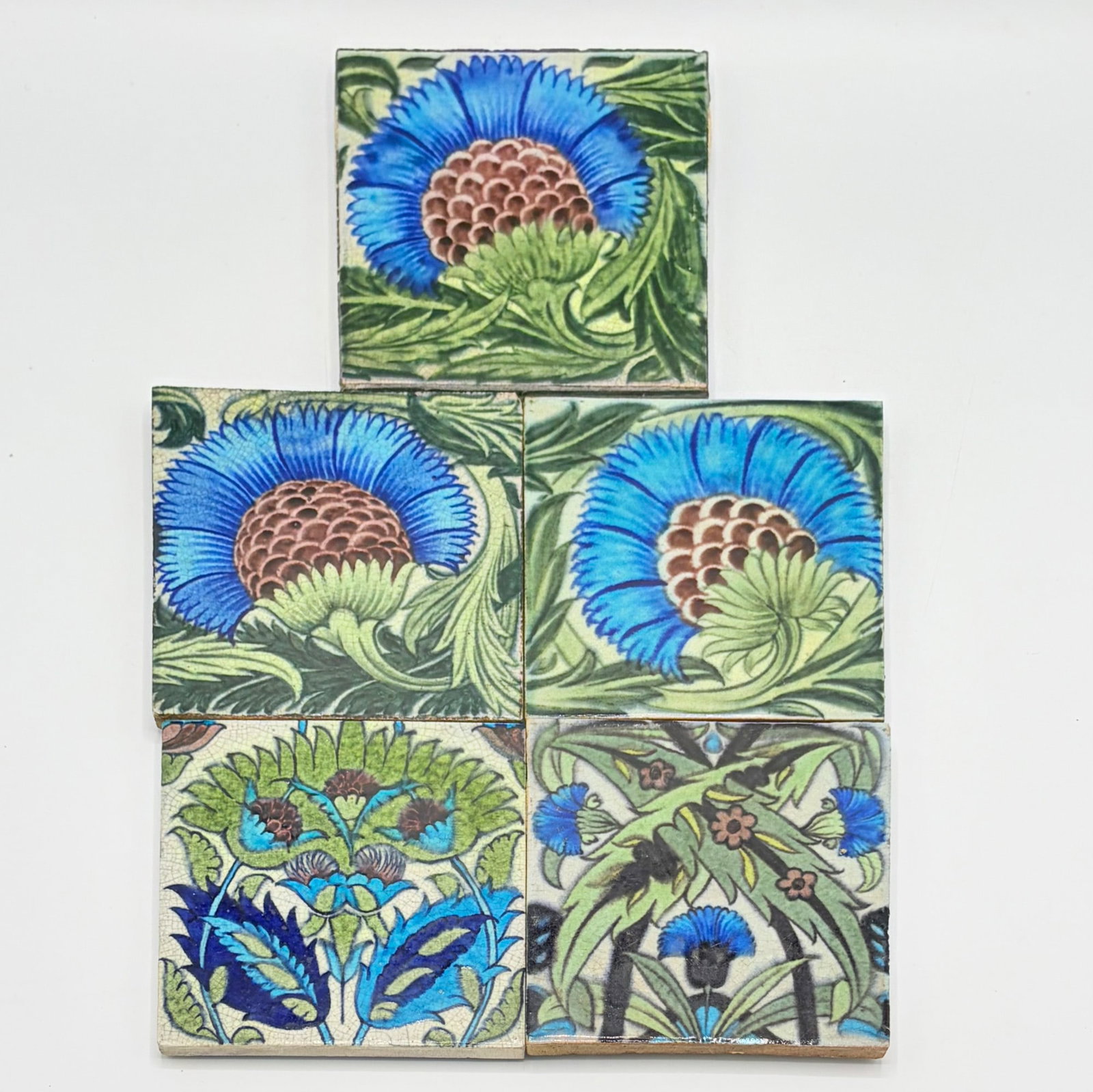 Five William De Morgan Glazed Earthenware Tiles: England, circa 1882-1897 Three B.B.B. design tiles, with two Islamic design tiles. Two examples with impressed Sand's End Pottery-Fulham mark to reverse, one example with impressed Sand's End Pottery 