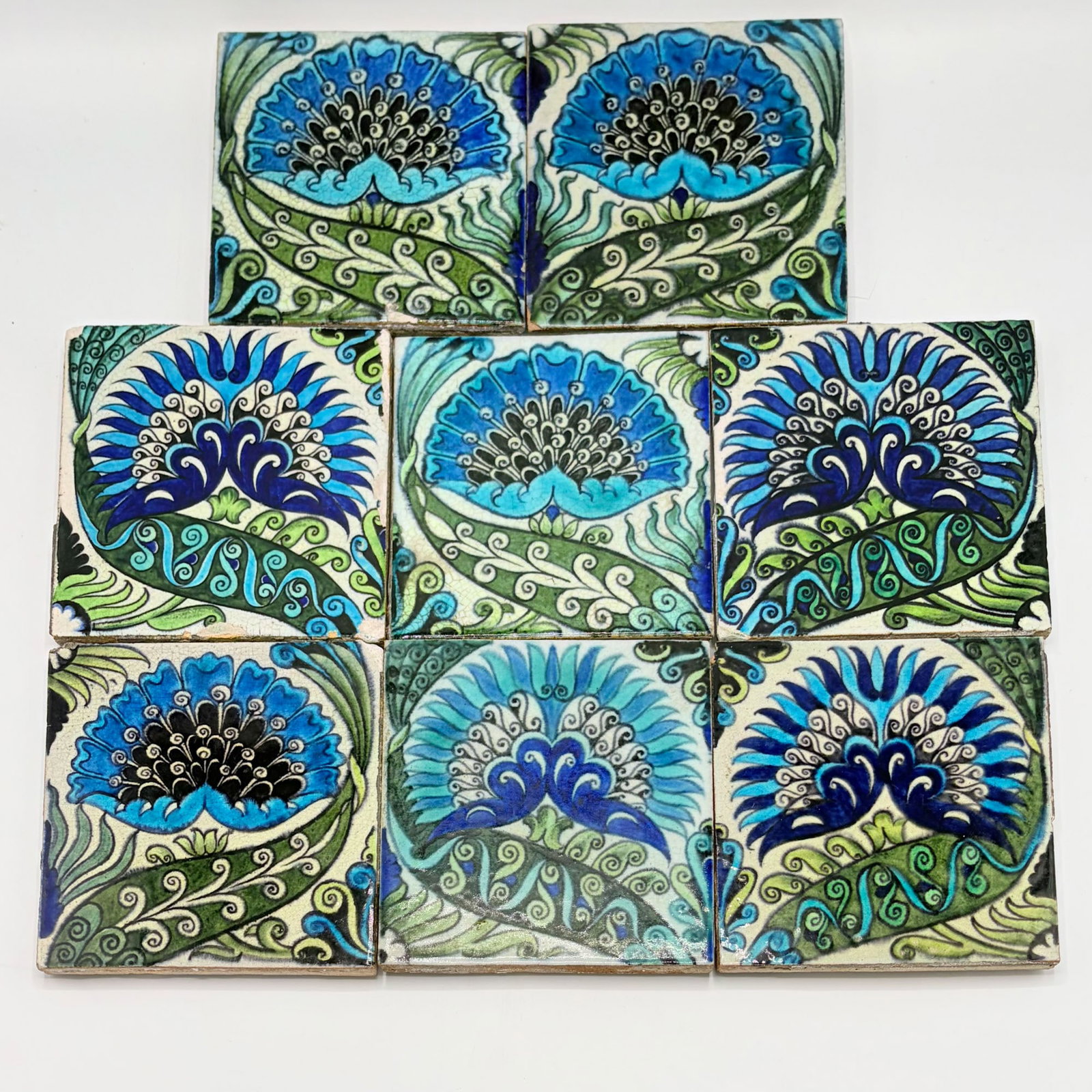 Eight William De Morgan Glazed Earthenware "Mongolian" Tiles: England, circa 1888-1898 Four examples with an impressed DM 98 mark to the reverse, two examples with an impressed Sand's End Pottery-Fulham mark to the reverse, and two examples with an impressed San