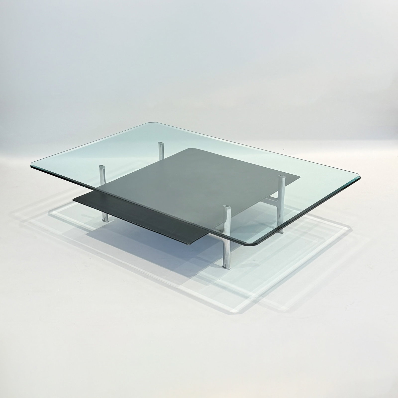 Antonio Citterio and Paolo Nava for B & B Italia "Diesis" Two-Tier Low Table: Polished aluminum, leather, and glass. The leather stamped B&B ITALIA. Height 13 1/2 inches, width 58 3/4 inches, depth 38 1/2 inches.