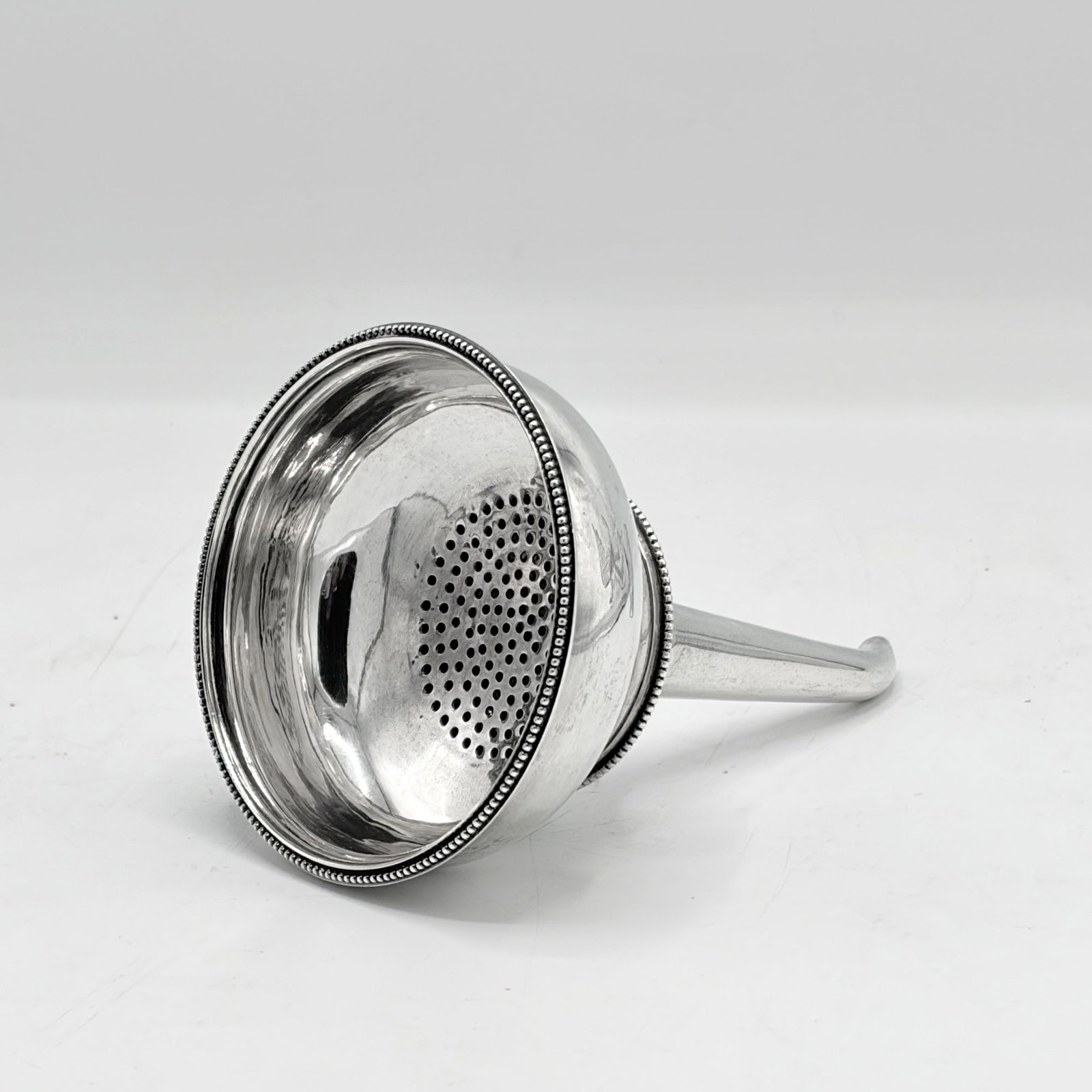 George III Sterling Silver Wine Funnel: Hester Bateman, London, 1785 Length 5 1/8 inches, approximately 3 ounces; Together with a Silver Plated Wine Funnel. Length 4 1/2 inches.