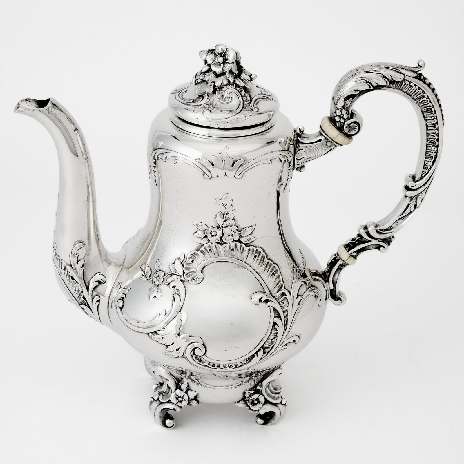 Austrian Silver Teapot: Late 19th century Baluster-form with rocaille cartouche, the hinged cover with foliate finial, raised on foliate scroll feet. Height 8 3/4 inches, approximately 25 ounces. This item may contain