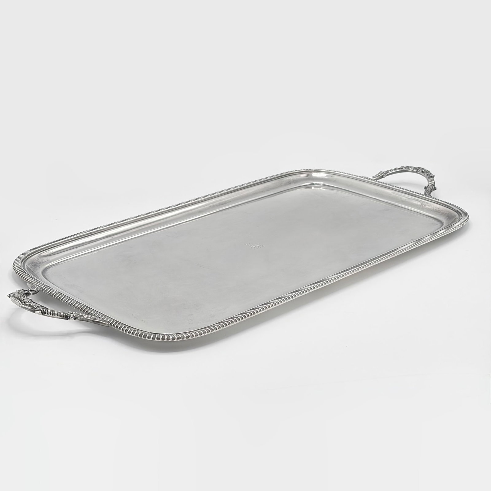 George V Sterling Silver Two-Handled Tray: Goldsmiths & Silversmiths Co. Ltd., London, 1914 Rectangular with foliate loop handles. Length over handles 23 1/2 inches, approximately 60 ounces.