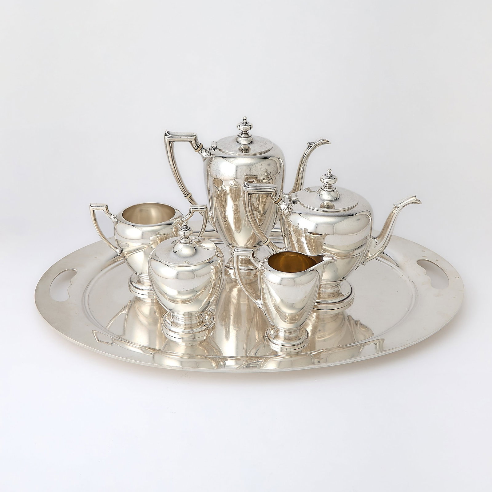 Reed & Barton Sterling Tea and Coffee Service: 20th Century Comprising a teapot, coffee pot, cream jug, covered sugar bowl, waste bowl and two-handled tray. Height of coffee pot 9 1/2 inches, length of tray over handles 24 1/2 inches, total