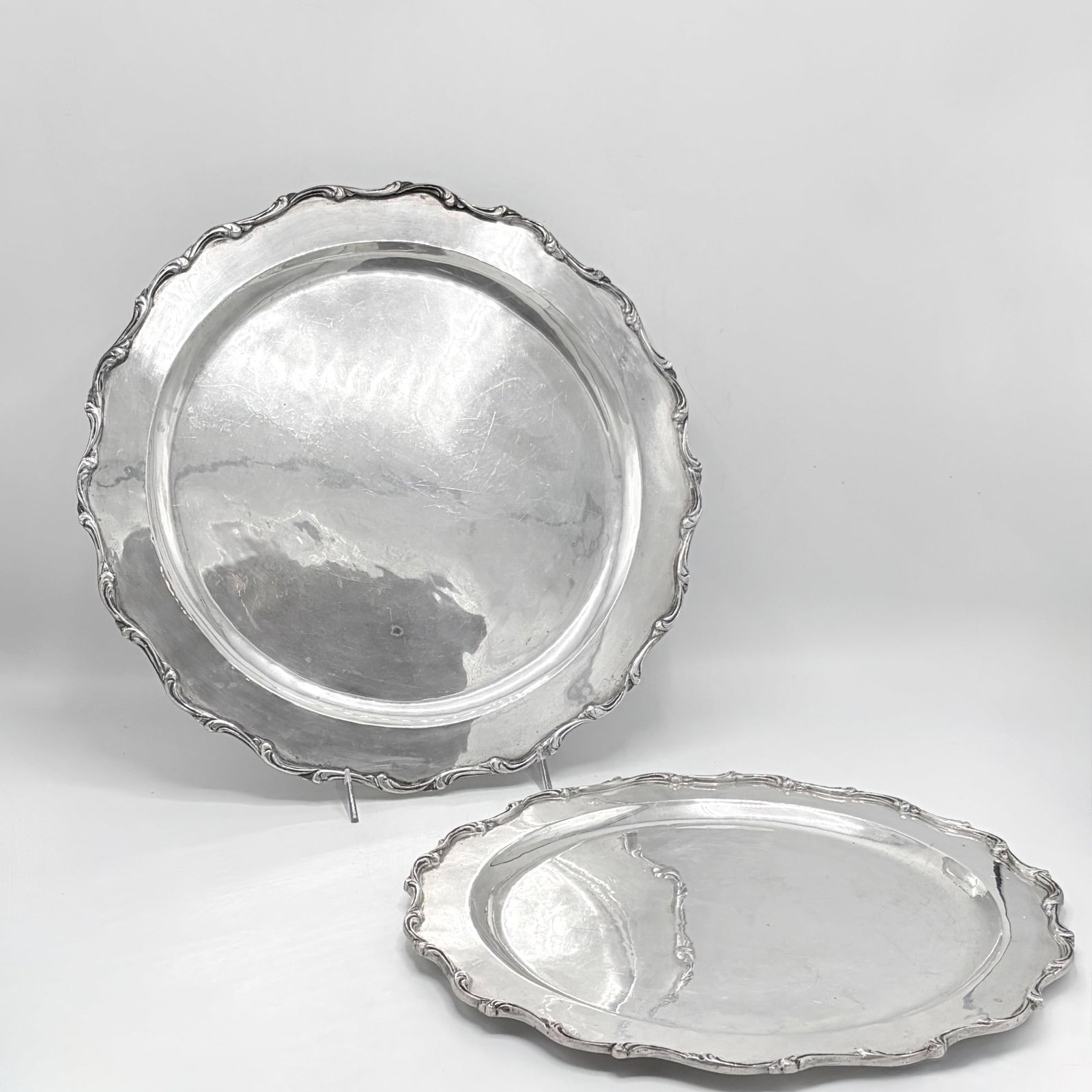 Two Mexican Sterling Silver Trays: G. Olvera, 20th century Shaped circular with applied scroll border. Diameter of larger 15 3/4 inches, total approximately 62 ounces.