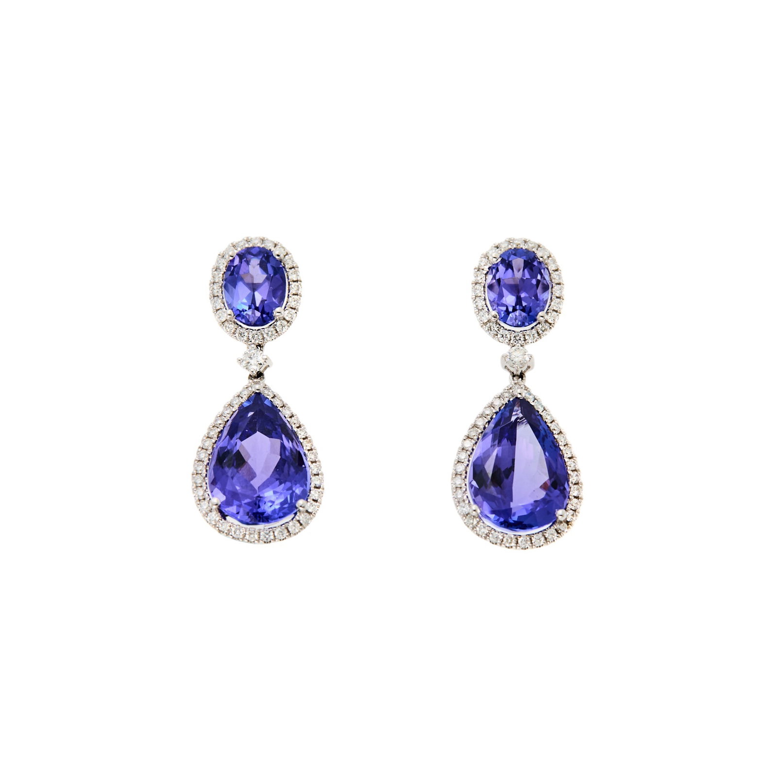 Kiki McDonough Pair of White Gold, Tanzanite and Diamond Pendant-Earrings: 18 kt., 2 pear-shaped tanzanites ap. 11.00 cts., 2 oval tanzanites ap. 2.50 cts., 104 round diamonds ap. 1.20 ct., signed kiki, with English assay marks, ap. 6 dwts. Tanzanites: deep bluish-violet,
