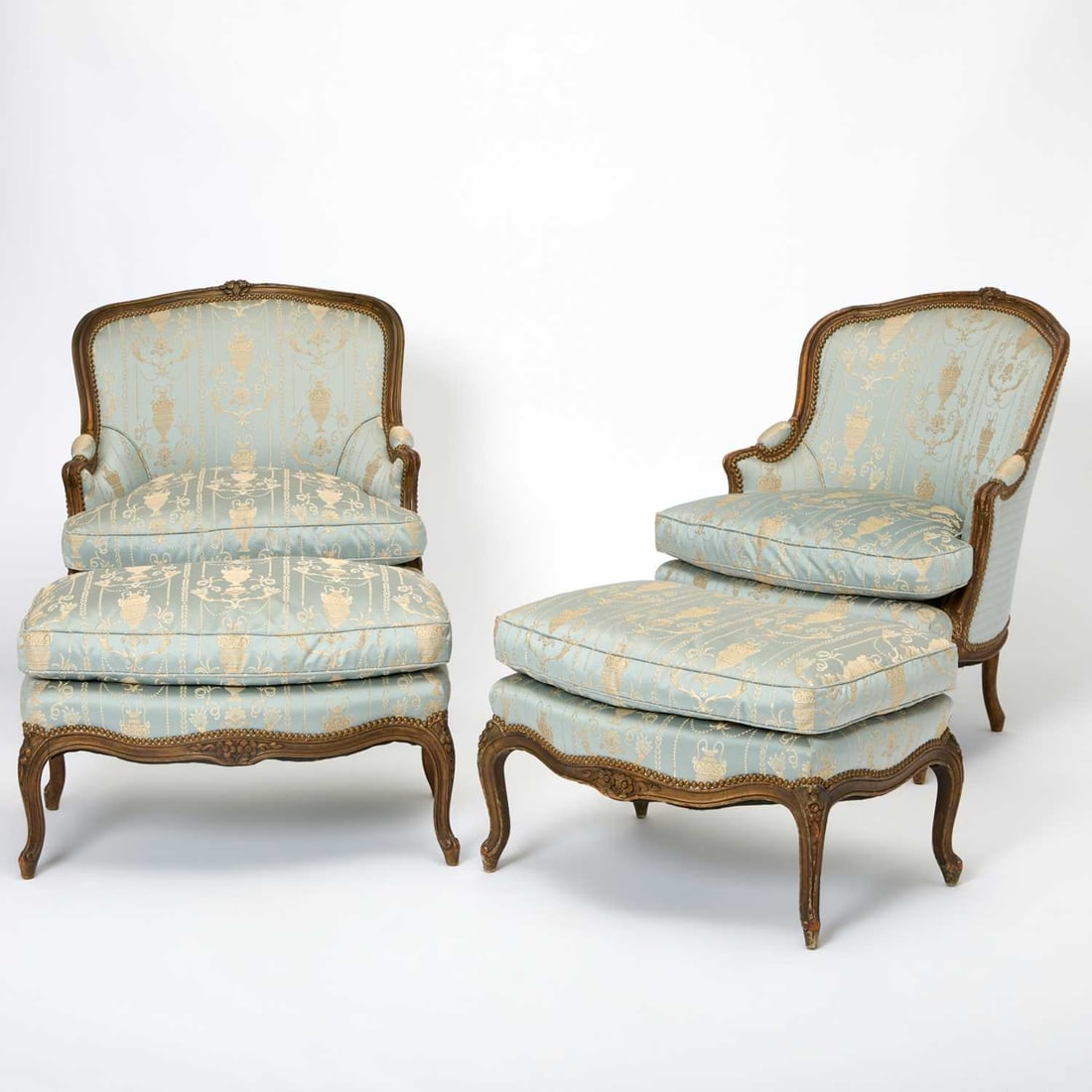 Pair of Louis XV Style Upholstered Carved and Painted Wood Duchesses Brisée: Early 20th century Height of bergère 34 inches, width 31 inches, depth 29 inches; seat height 18 inches; height of stool 17 inches, width 29 inches, depth 18 inches.