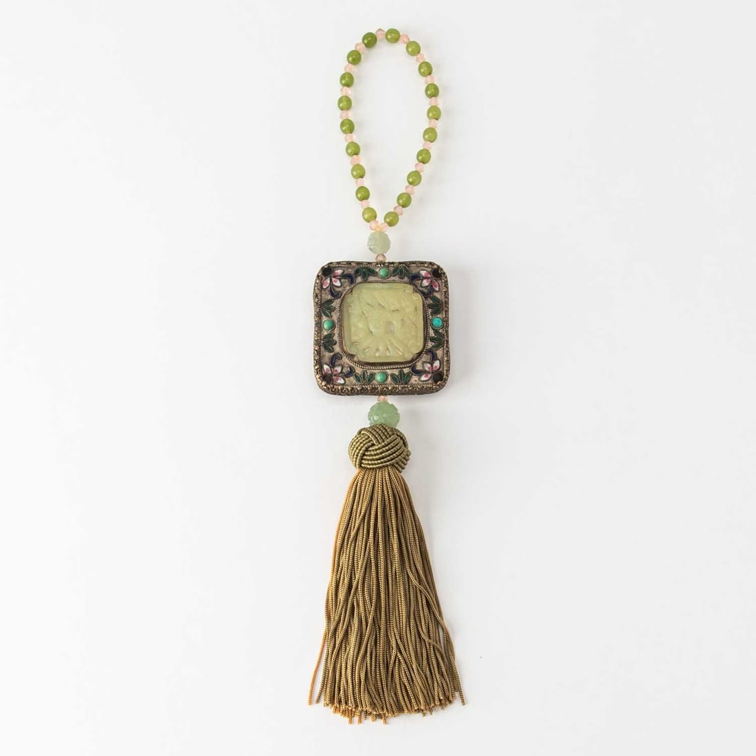 A Chinese Gem-Inset White Metal and Carved Jade Pendant: Decorated with floral motifs. (Length 14 inches)