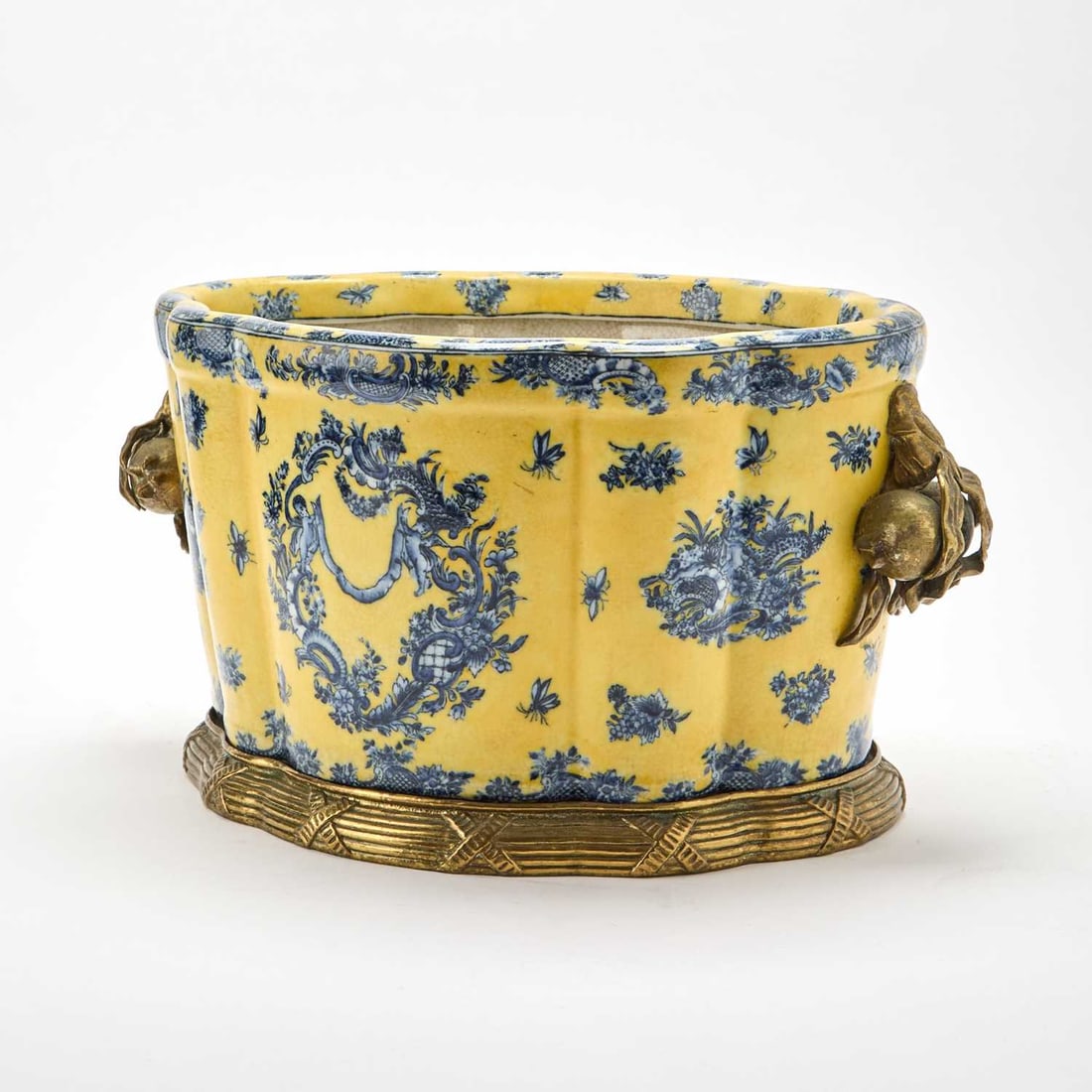 United Wilson Porcelain Factory Chinese Style Metal-Mounted Porcelain Jardiniere Planter: Of oval form with a lobed body, decorated with classic cobalt Chinoiserie floral and cherub motifs, against a yellow ground, signed on th eunderside with the company's blue UW backstamp. Height 9 3/4