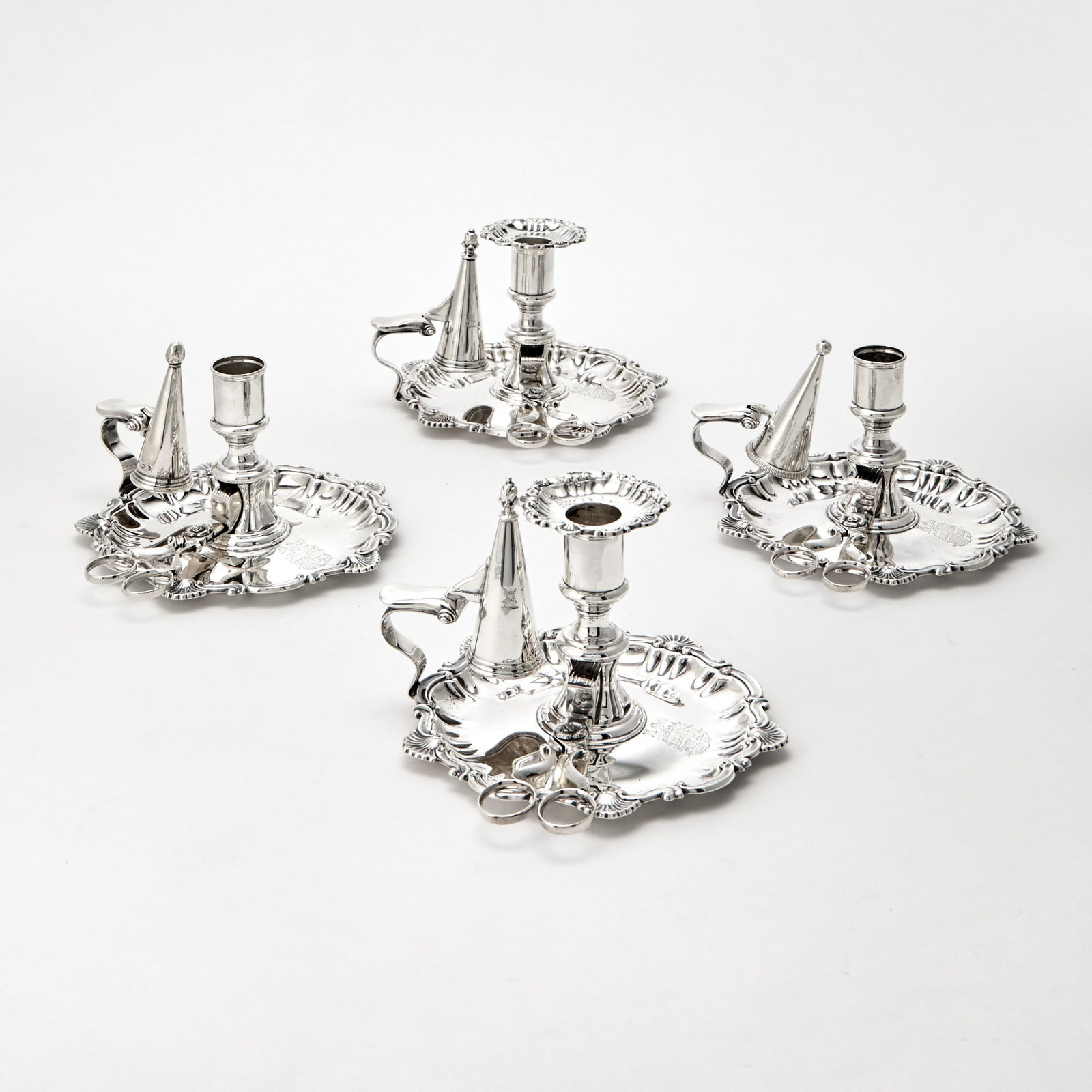Set of Four Victorian Sterling Silver Chambersticks: Mark of Thomas Bradbury & Sons, Sheffield, 1837 Each shaped circular with shell and scroll border, with scissors and conical snuffer. Length over handle 6 3/4 inches (17 cm), total approximately 3