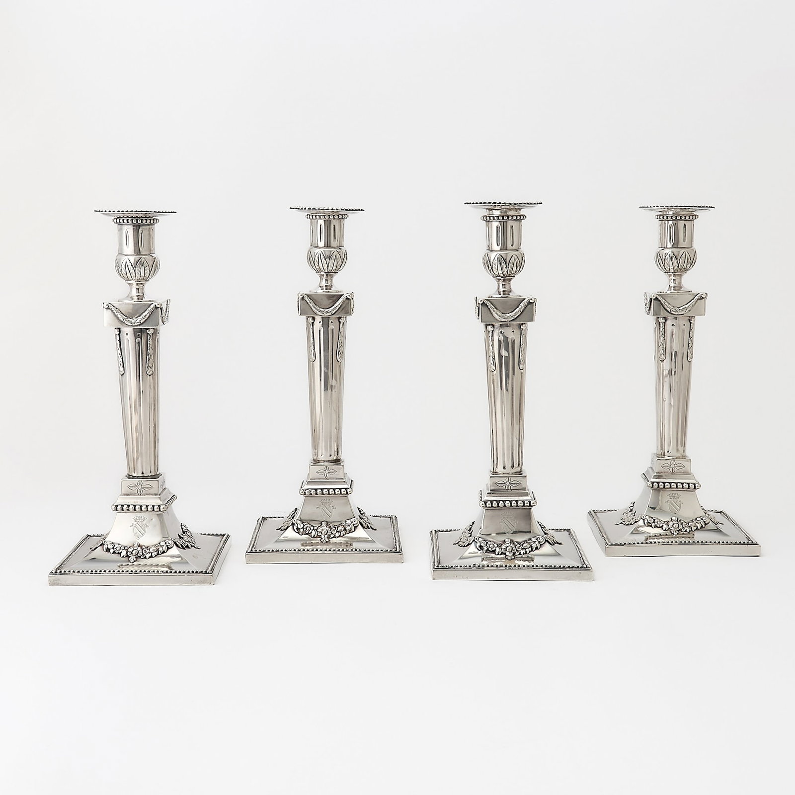 Set of Four Dutch Neoclassical Style Silver Candlesticks: 19th Century Each with a fluted columnar stem hung with swags, on a square base with floral swags and beaded rims. Height 11 inches (28 cm), total approximately 74 ounces.
