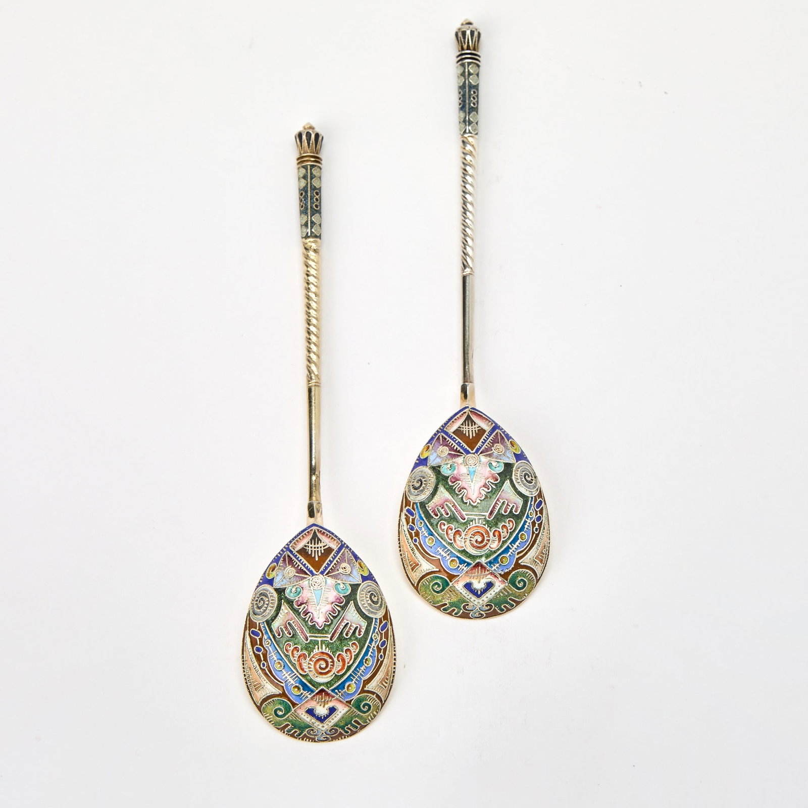 Pair of Russian Silver-Gilt and Cloisonné Enamel Spoons: Fabergé, Moscow, 1908-1917 Each with a spiral-twist stem and pear-shaped bowl enameled with varicolored shaded stylized foliage and geometric motifs, in a fitted wood case. Length 7 inches (17.8 