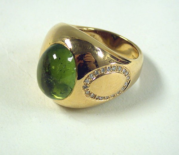 Gold and Tourmaline ring: Gold and Tourmaline ring The 18 kt. pink gold mounting set to the center with a green tourmaline, decorated to one side with assorted small round diamonds, signed Antonini, approximately 10.9 dwt. Siz