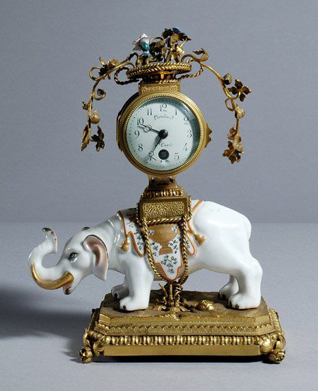 Louis XV Style Gilt-Metal and Gilt Decorated Porc: Louis XV Style Gilt-Metal and Gilt Decorated Porcelain Mantel Clock Lievland a Paris Modeled as a white elephant in a stationary pose, saddled with a pedestal clock having a circular dial, on a natur