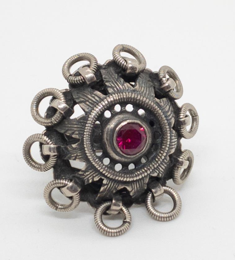 David Anderson Uni Kopi Fra Folkemuseet Garnet Ring Mid: A unique mid century ring from David Anderson, designed by Uni, in sterling silver featuring a 5.7mm round faceted garnet bezel set in an intricate and pierced 1.25" mount surrounded with dangling lin