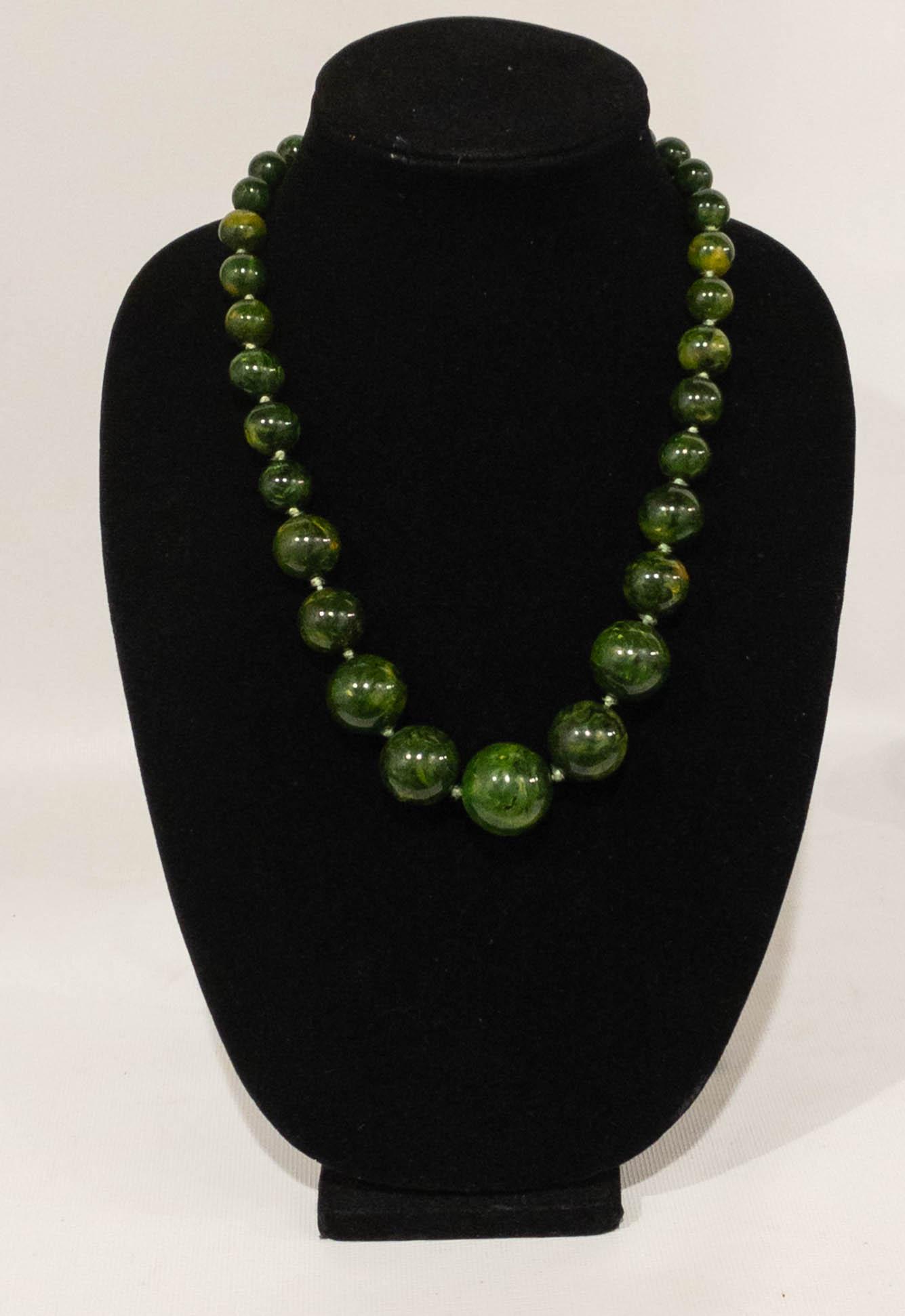 Vintage Green Bakelite Bead Graduated Strand Necklace: Bakelite bead strand necklace graduating from 9mm to 24mm. Each bead is hand knotted. 34" long.