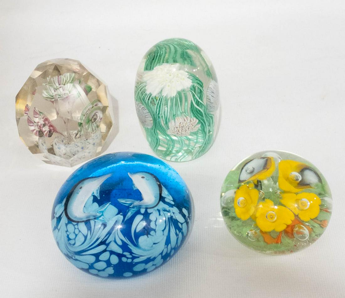 4 Murano Glass Colorful Paperweights: A collection of glass paperweights including: a blue round paperweight featuring jumping dolphins, 2" high, 4" diameter, a round yellow calla lily flower paperweight, 2" high, 3" diameter, an oval whi
