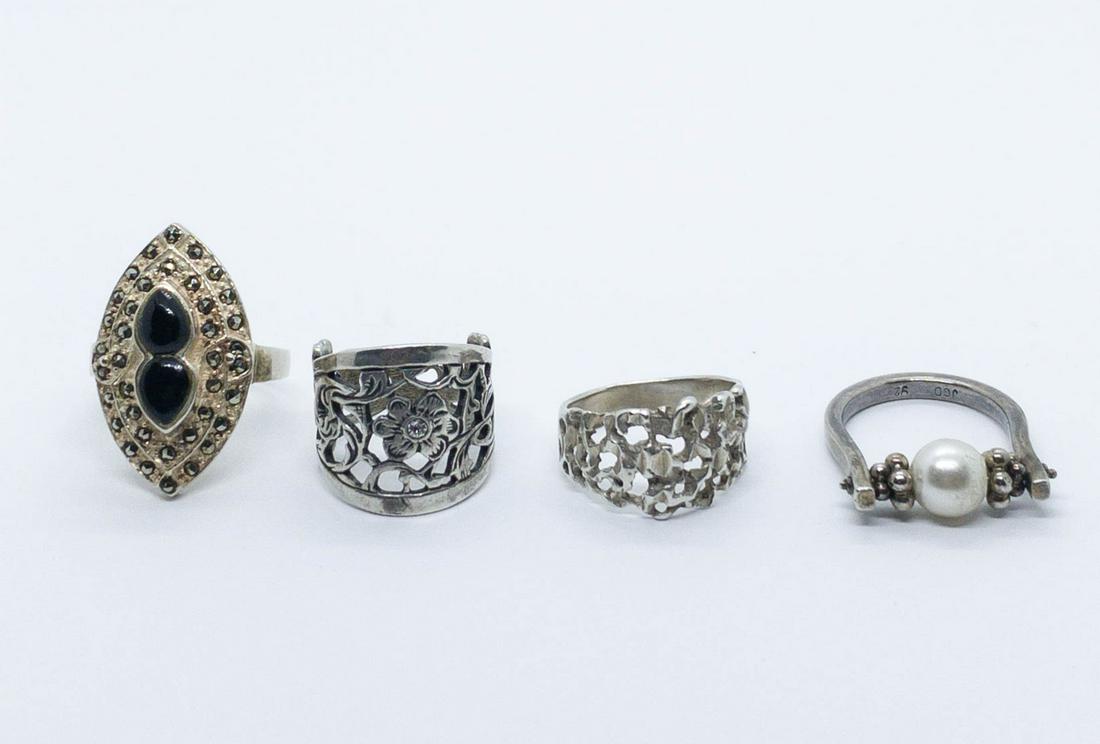 Lot of 4 Sterling Rings Onyx Crystal: A lot of 4 sterling silver rings: onyx and marcasite ring size 8, pierced floral and crystal ring size 5.5, nugget ring size 6, faux pearl ring size 7. Total weight: 20.4 grams.