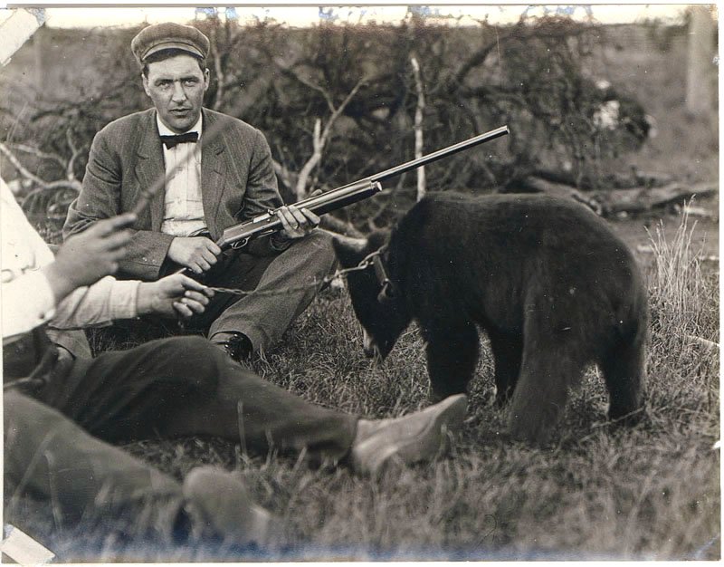 c1910 Photo BEAR HUNTER & Chained Cub Remington Shotgun: This is a vintage circa 1910-1920 black & white real photograph of man with shotgun and bear cub. It looks like the man could be holding a Remington Model 11 (Browning A-5) semi-automatic shotgun. Mos